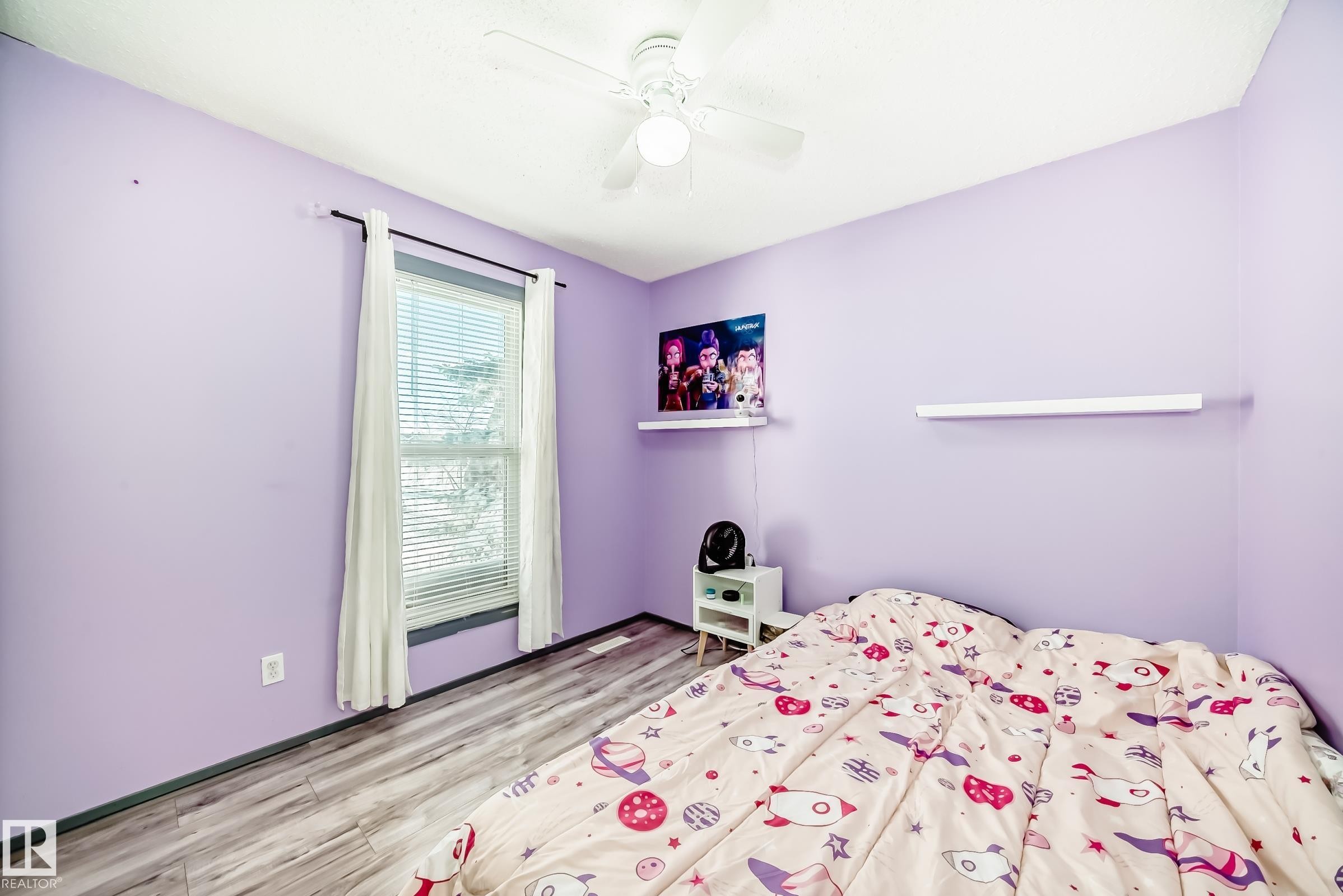 Room with wood-finish flooring and a white ceiling fan - 214A Warwick Road, Edmonton, AB - Indoor Photo Showing Bedroom
