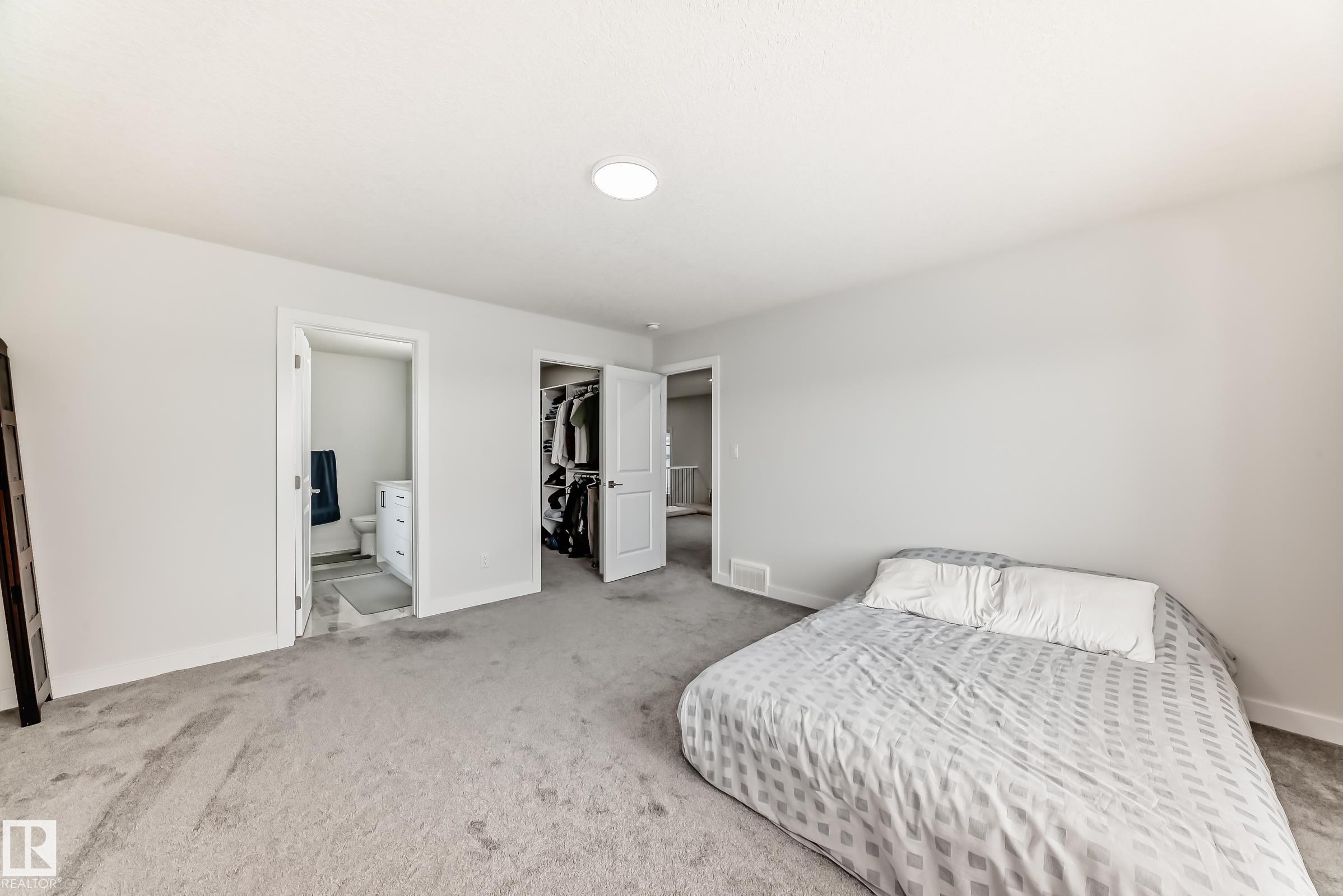 This room features light gray carpeting, neutral-toned walls, and a recessed ceiling light fixture - 4509 170A Avenue, Edmonton, AB - Indoor Photo Showing Bedroom