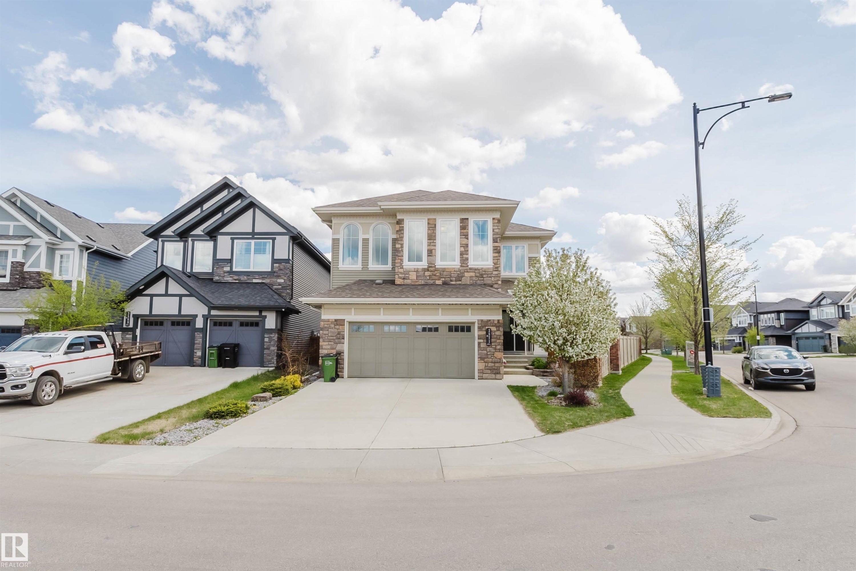 Two-story residence featuring a stone and stucco exterior, an attached two-car garage, and a concrete driveway - 3571 Keswick Boulevard, Edmonton, AB - Outdoor With Facade