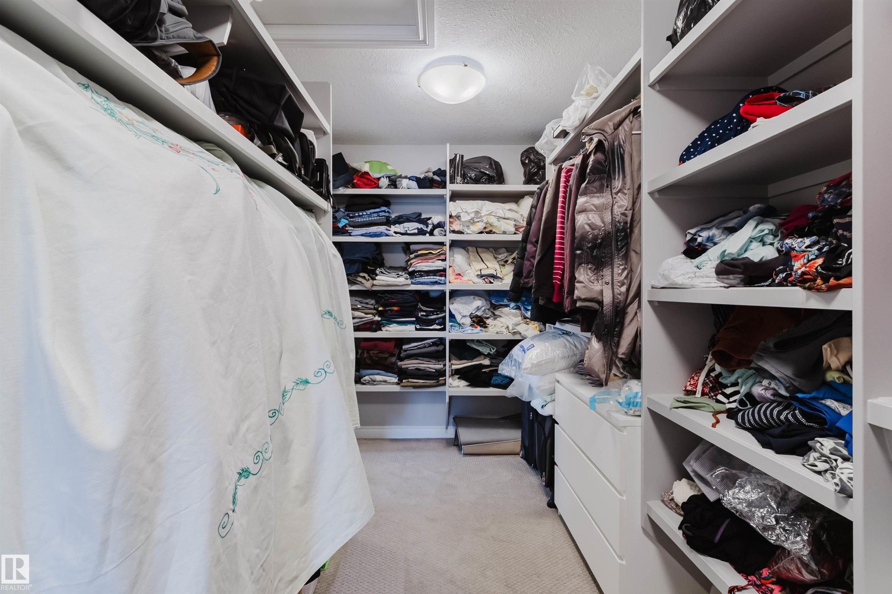 Walk-in closet featuring built-in shelving, hanging rods, recessed ceiling light, and carpet flooring - 3571 Keswick Boulevard, Edmonton, AB - Indoor With Storage