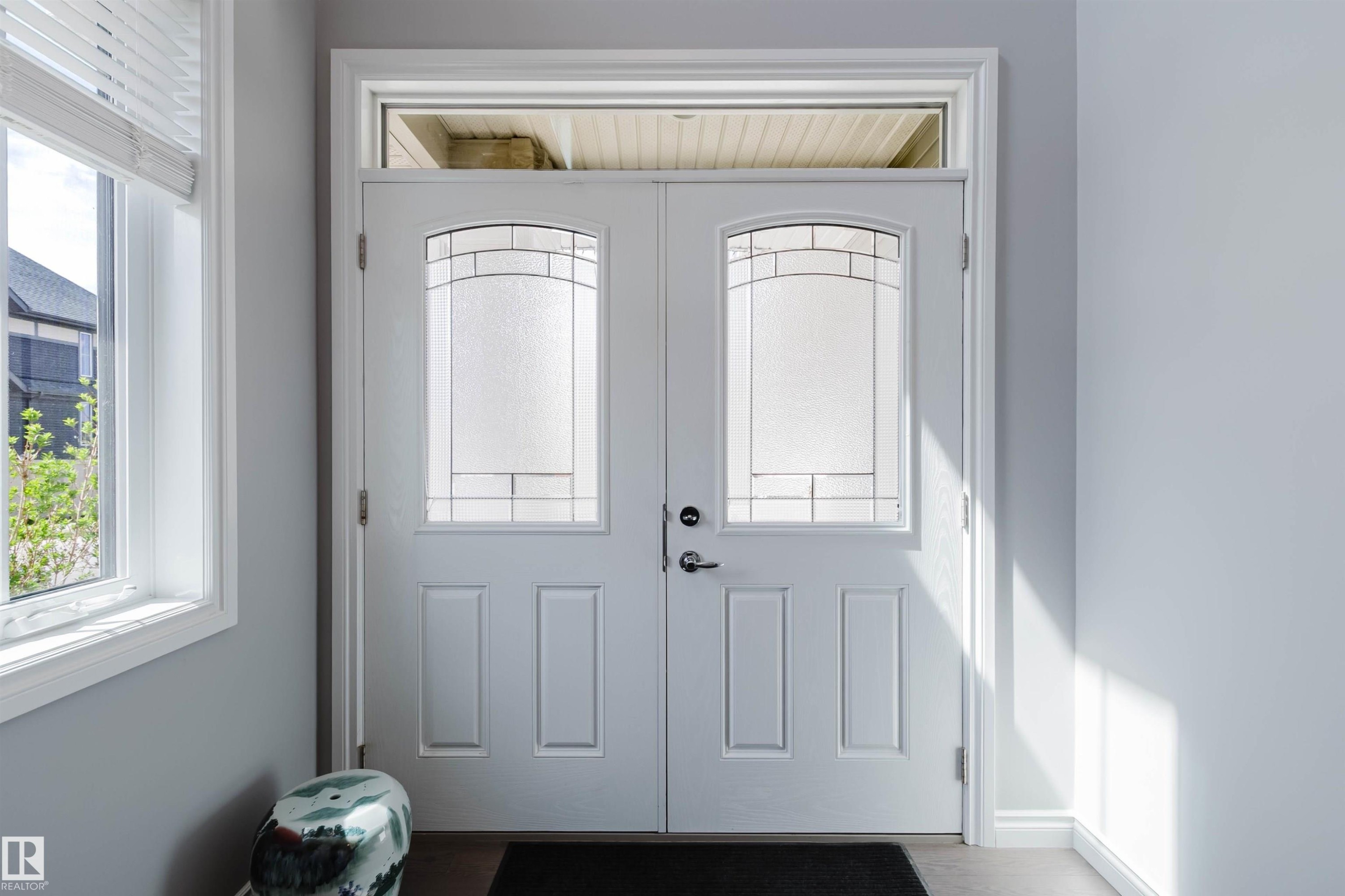 Double entry doors featuring decorative glass inserts and an overhead transom window - 3571 Keswick Boulevard, Edmonton, AB - Indoor Photo Showing Other Room