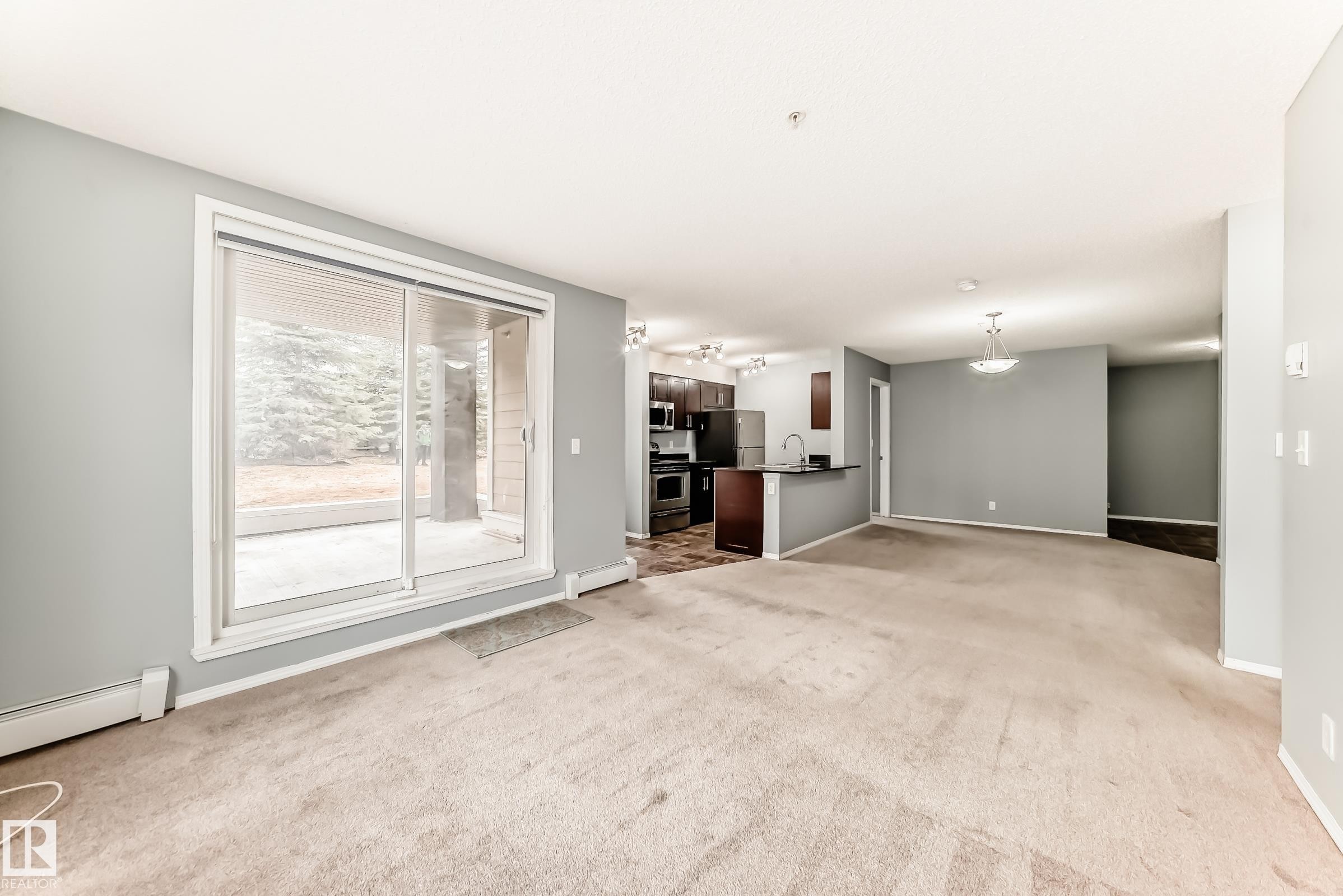 Open concept living area with light-colored carpeting and light gray walls - 101 530 Watt Boulevard, Edmonton, AB - Indoor