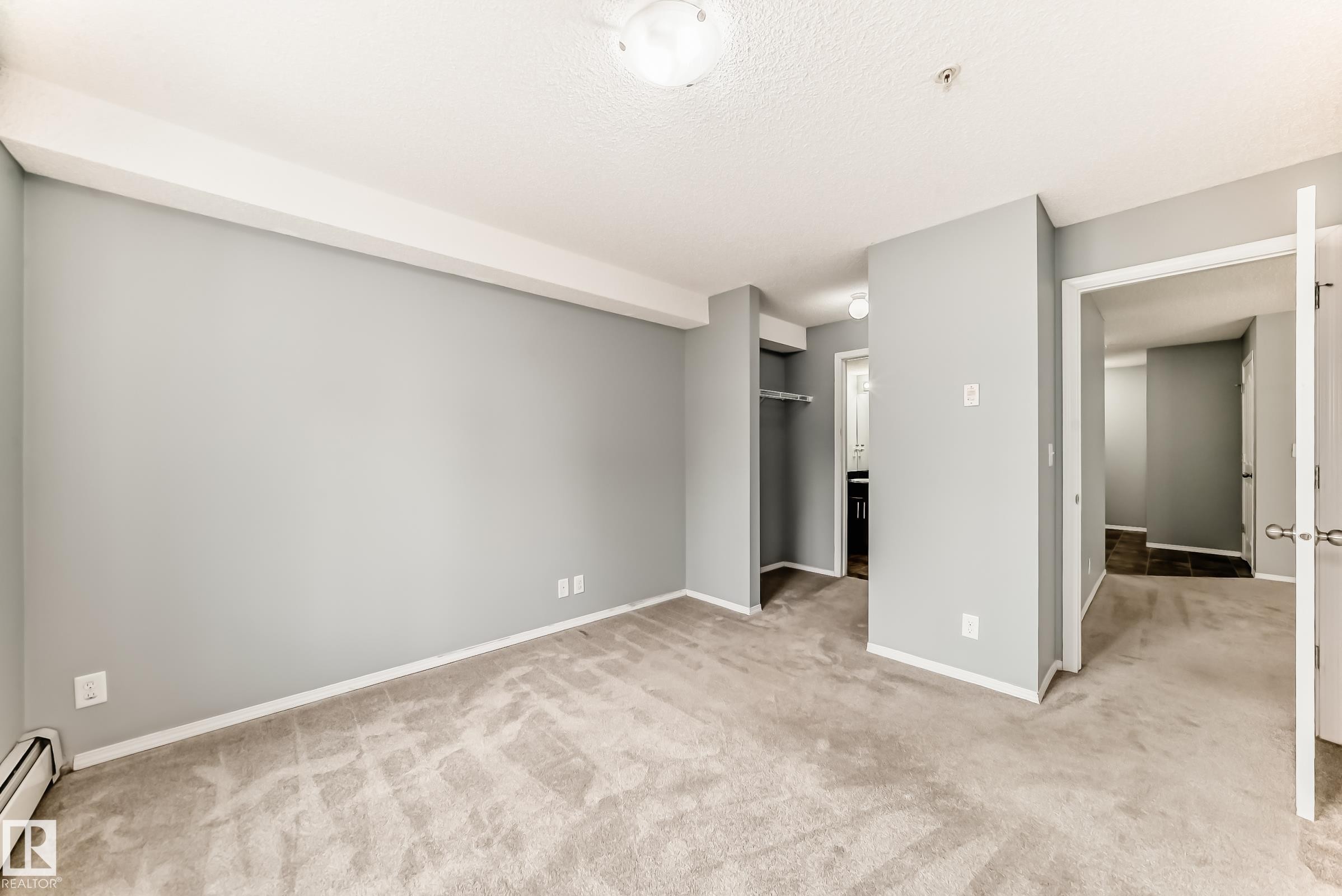 This room features light grey walls and light-colored carpeting, creating a bright and neutral aesthetic - 101 530 Watt Boulevard, Edmonton, AB - Indoor Photo Showing Other Room