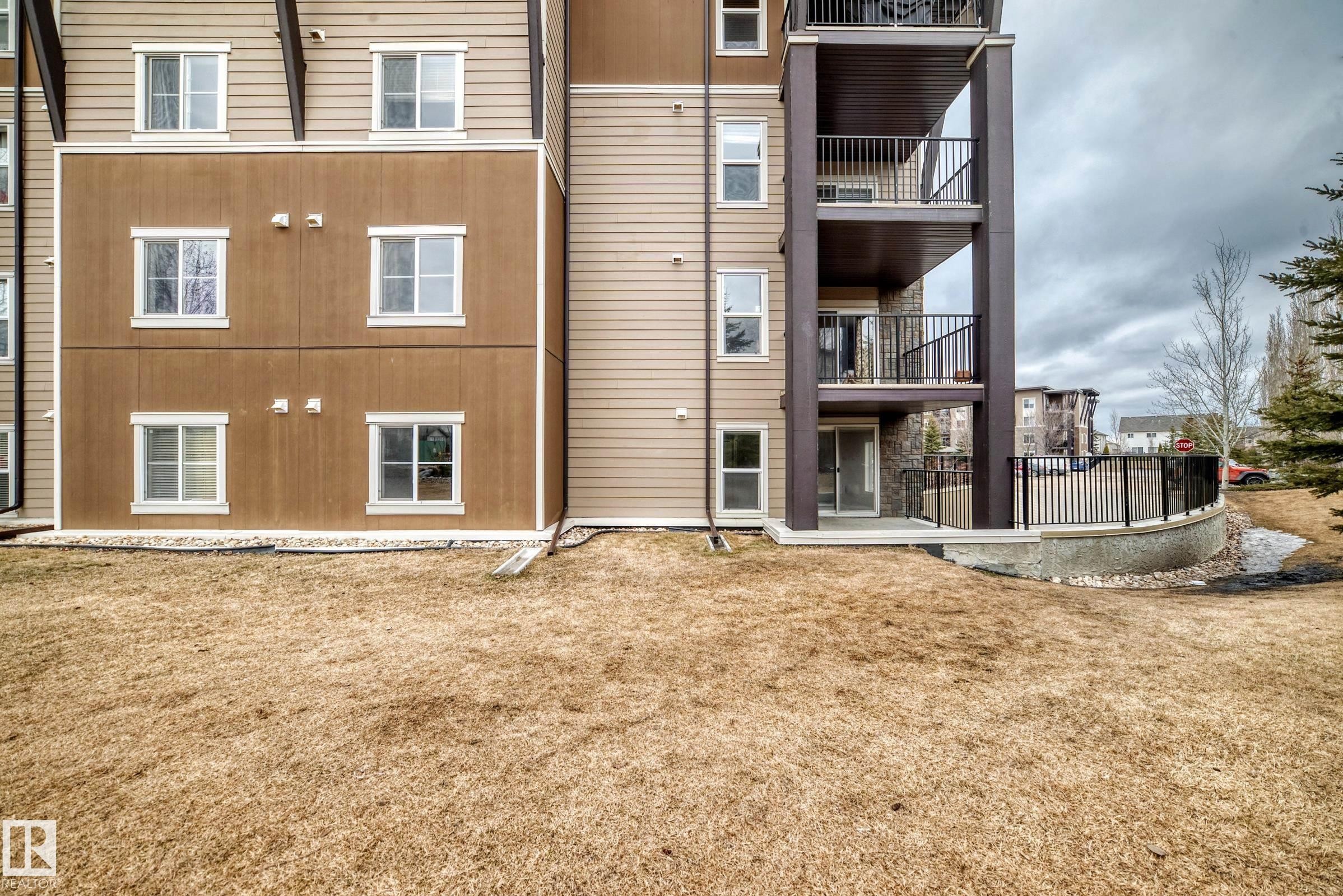 The property features a multi-level exterior with balconies and ground-level patios, offering private outdoor spaces - 101 530 Watt Boulevard, Edmonton, AB - Outdoor With Exterior