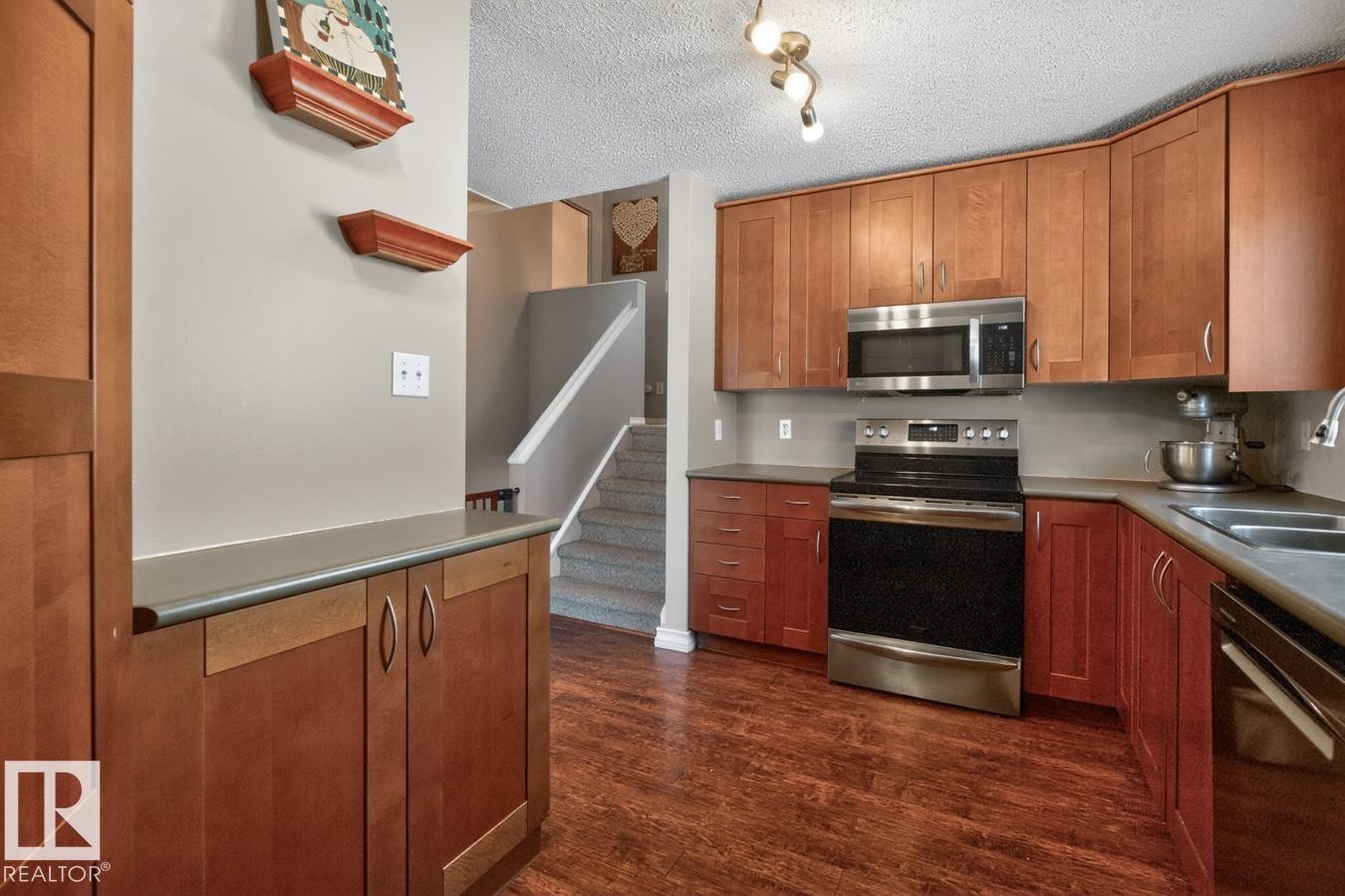 Kitchen featuring Stainless Steel Appliances, Ample Cabinets, Counter Space, and Storage with South Facing Window overlooking your Private Backyard. - 18655 61 Avenue, Edmonton, AB - Indoor Photo Showing Kitchen With Stainless Steel Kitchen With Double Sink