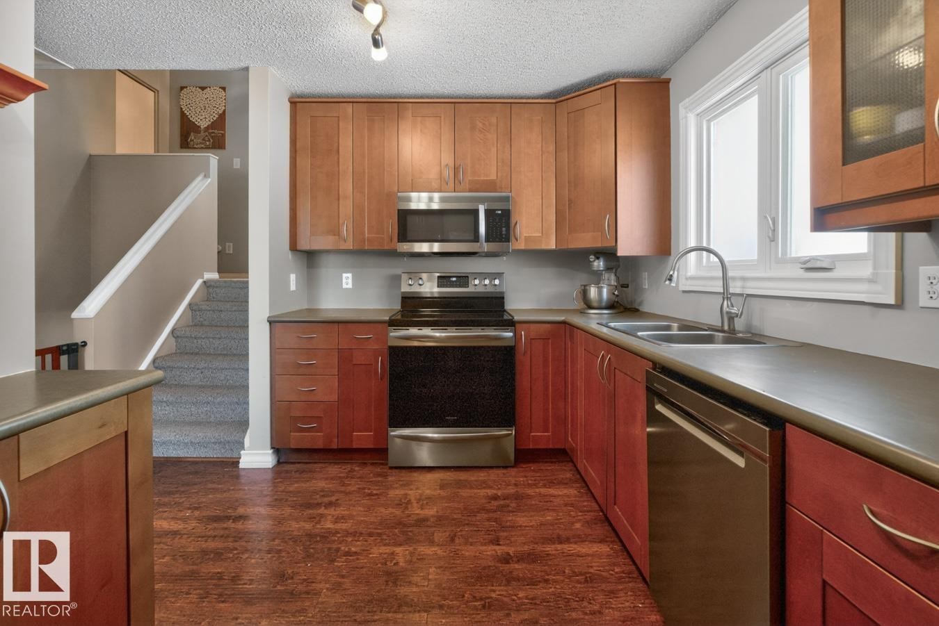 Kitchen featuring Stainless Steel Appliances, Ample Cabinets, Counter Space, and Storage with South Facing Window overlooking your Private Backyard. - 18655 61 Avenue, Edmonton, AB - Indoor Photo Showing Kitchen With Double Sink