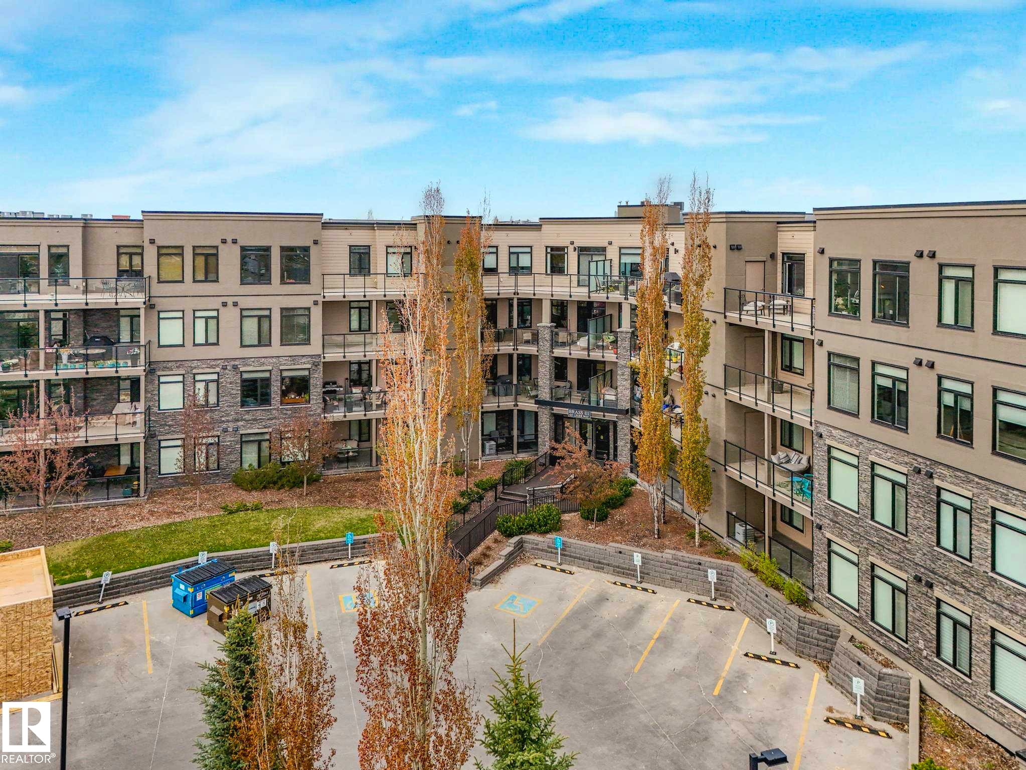 Multi-story residential building with private balconies and exterior stone accents - 213 625 Leger Way, Edmonton, AB - Outdoor With Balcony