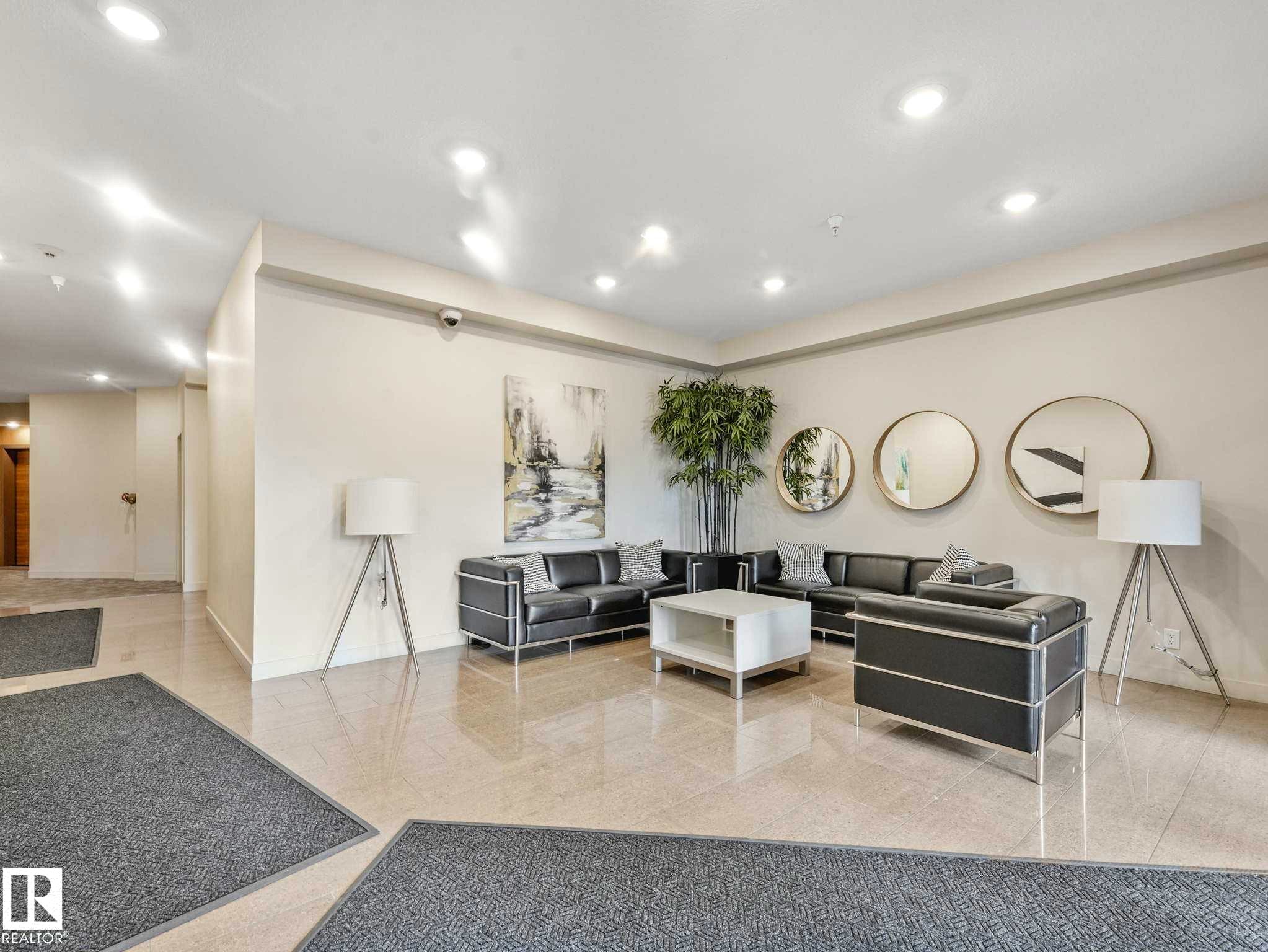 Lobby area featuring polished tile flooring, recessed lighting, and neutral wall tones - 213 625 Leger Way, Edmonton, AB - Indoor Photo Showing Other Room