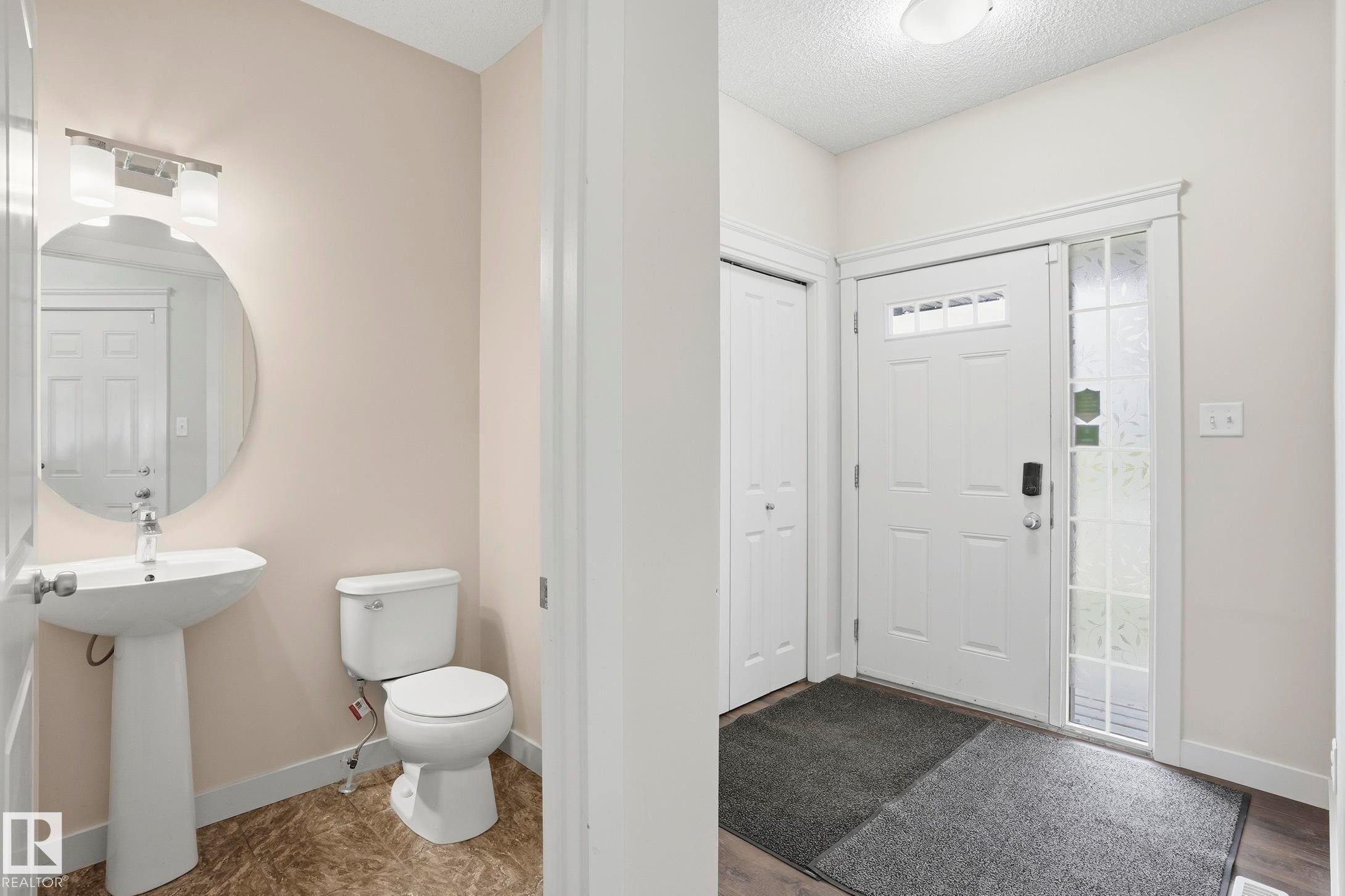 Entryway with a white paneled door featuring decorative glass inserts and an adjacent sidelight - 2917 16A Avenue, Edmonton, AB - Indoor Photo Showing Bathroom