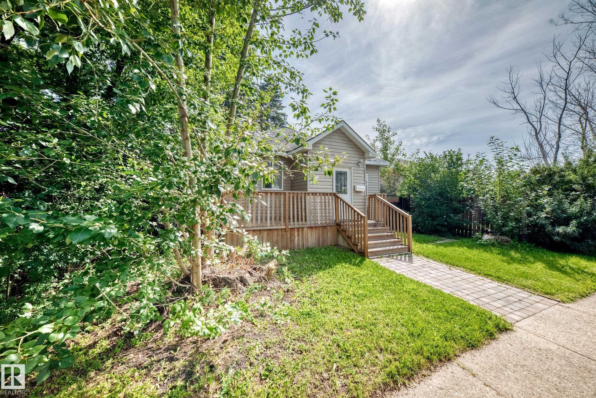 Siding exterior with a gable roof, wood deck, and wood railing with steps - 12627 71 Street Nw, Edmonton, AB