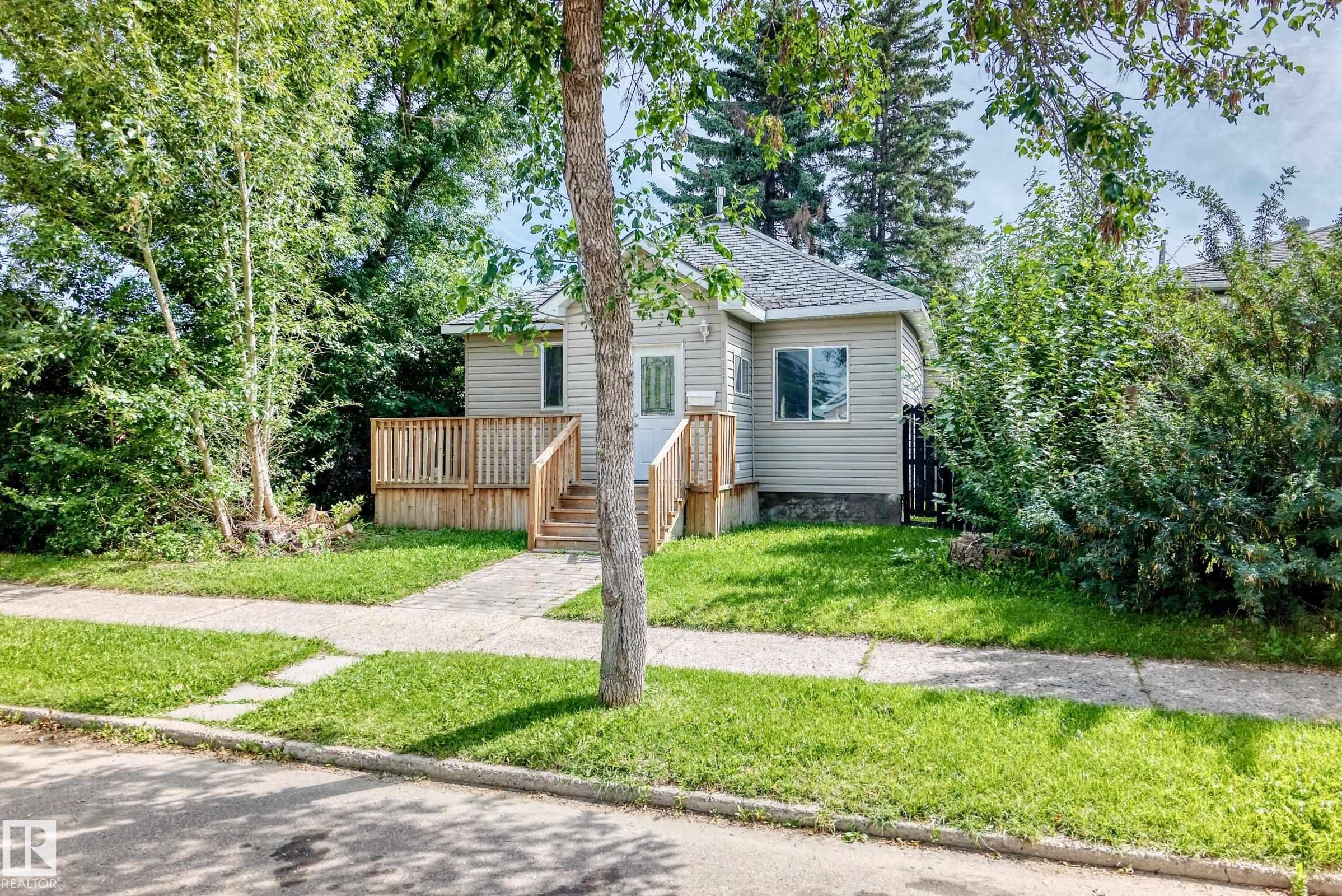 Single-story residence featuring light-colored siding and a gabled roof - 12627 71 Street Nw, Edmonton, AB