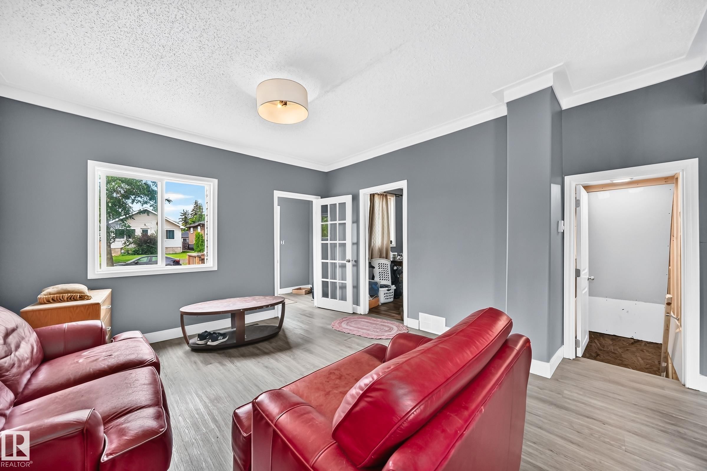 Wood-finish flooring, white trim, and a ceiling-mounted light fixture - 12627 71 Street Nw, Edmonton, AB