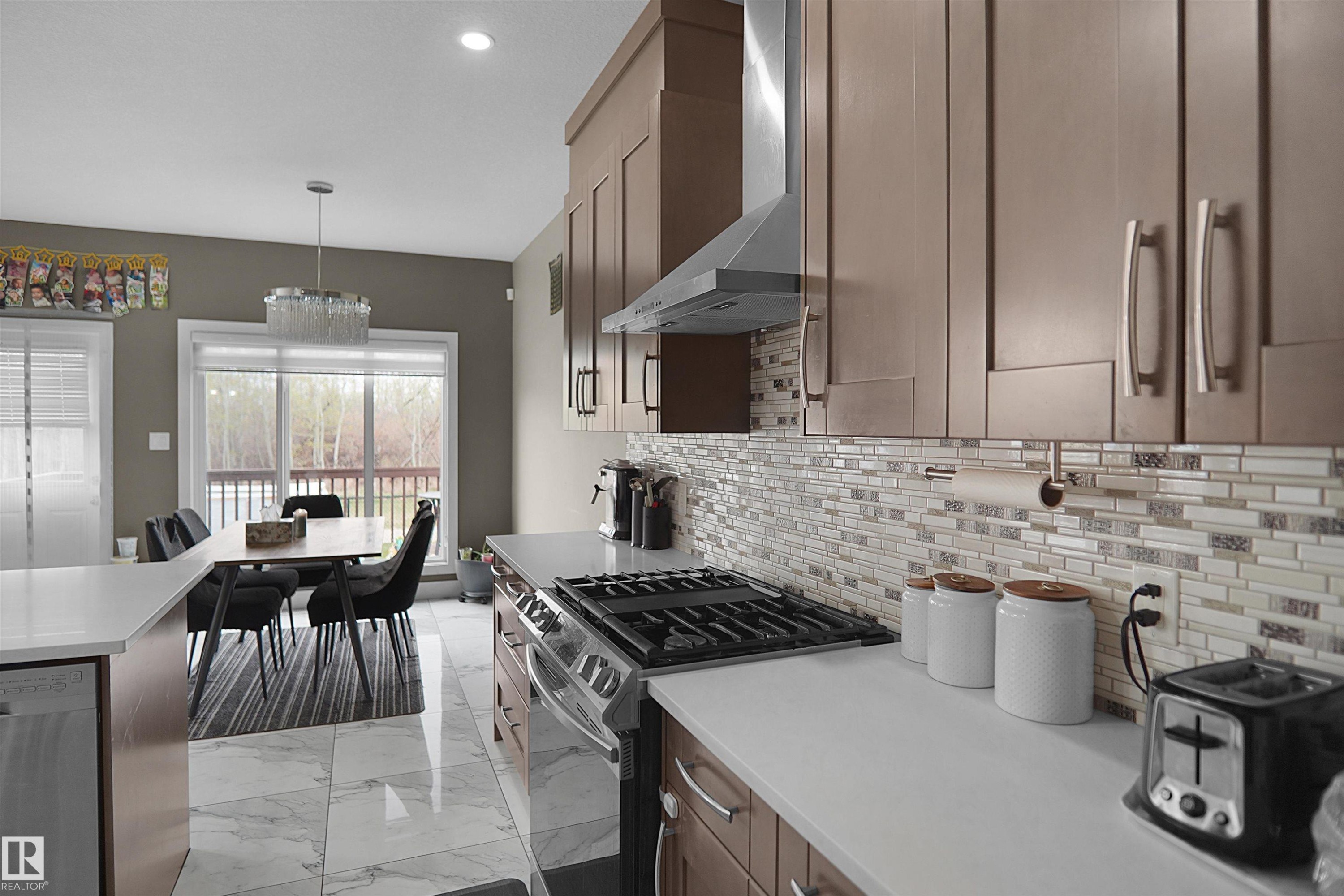 Modern kitchen featuring white countertops, stainless steel appliances, and wood-finish cabinetry - 6108 173 Ave, Edmonton, AB - Indoor