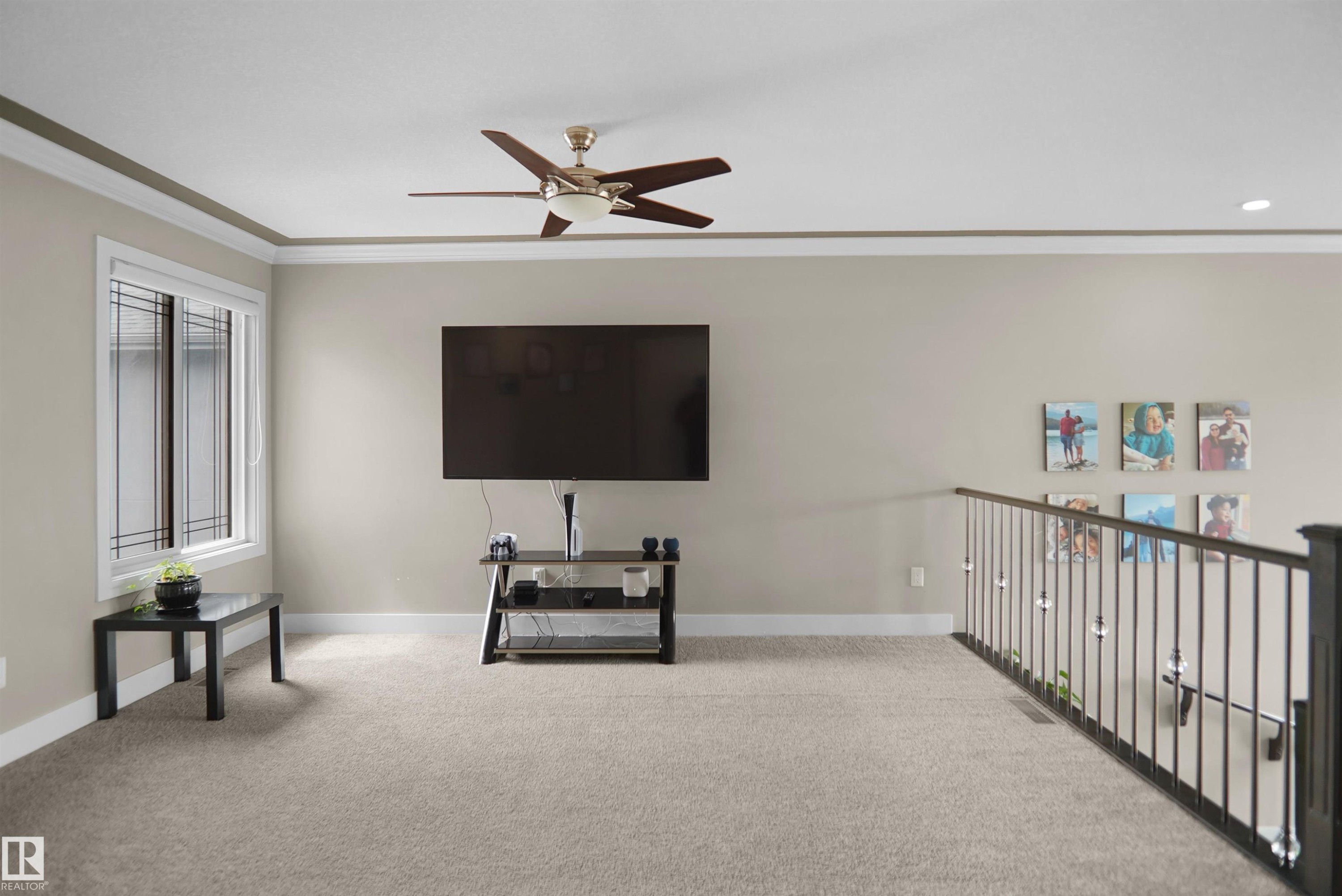 Carpeted upper-level space featuring a contemporary ceiling fan, recessed lighting, and a white-framed window with integrated grilles - 6108 173 Ave, Edmonton, AB - Indoor Photo Showing Other Room