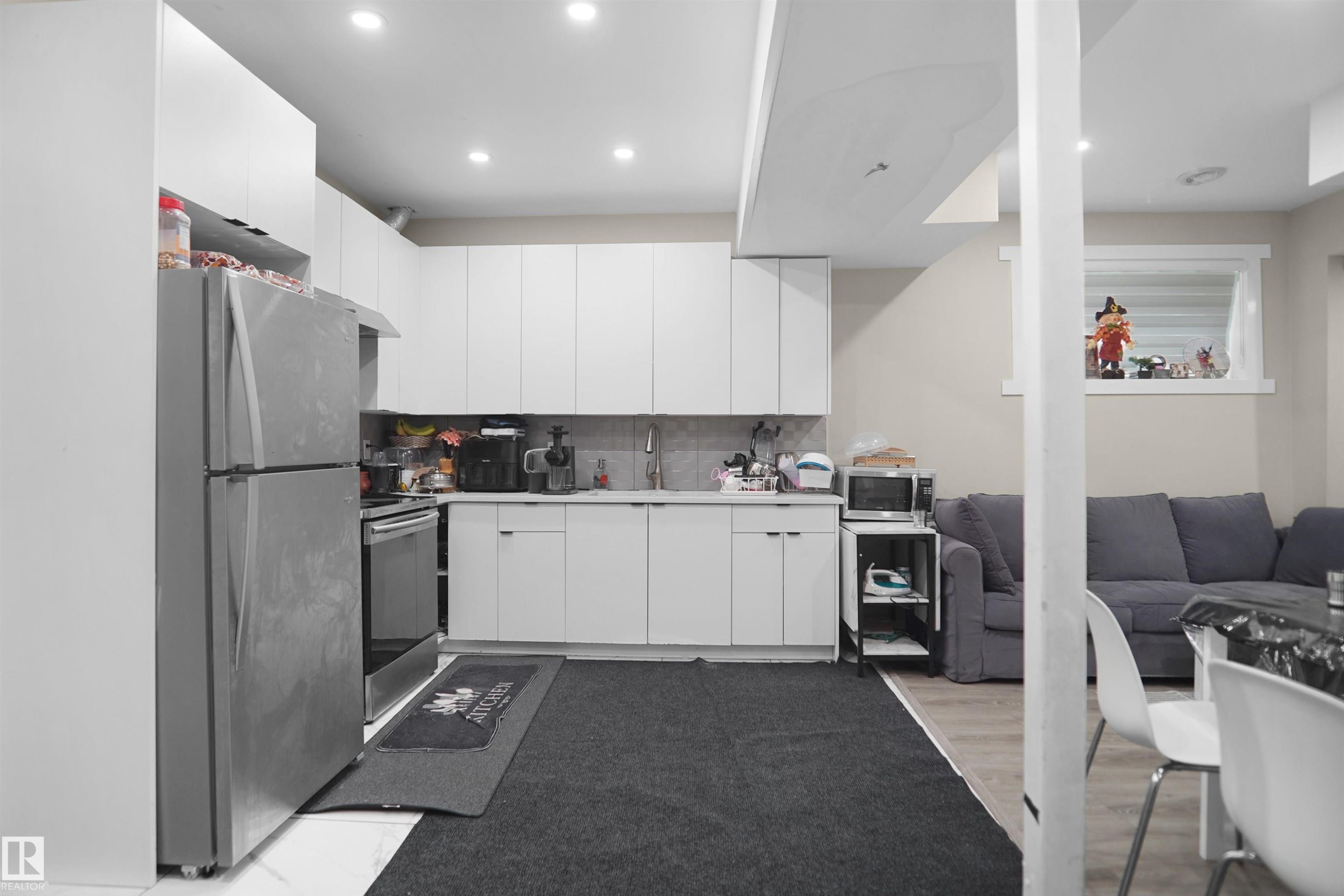 Contemporary kitchen featuring white cabinetry, stainless steel appliances, recessed lighting, and a tile backsplash - 6108 173 Ave, Edmonton, AB - Indoor Photo Showing Kitchen