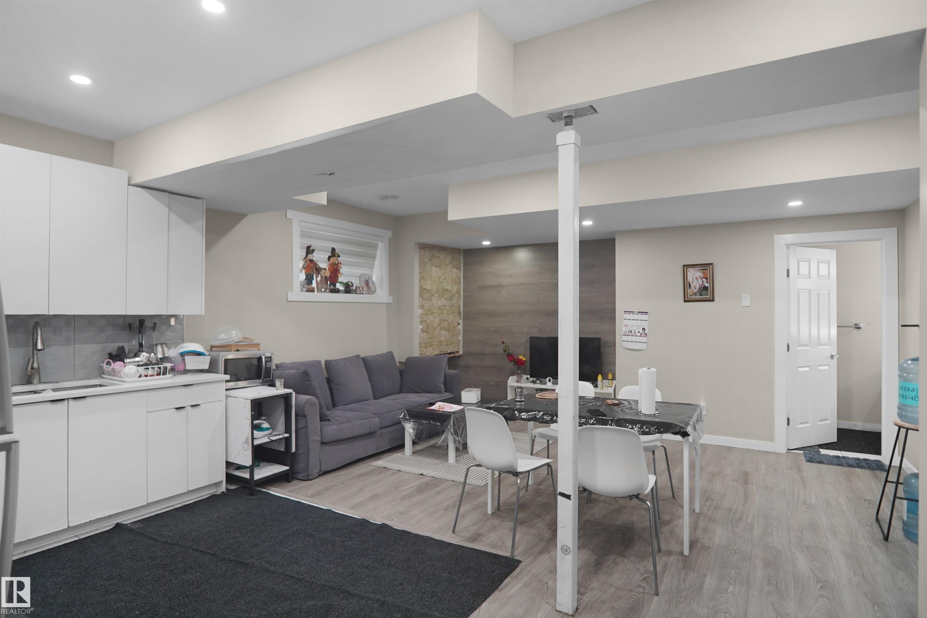 Open-concept living area featuring wood-finish flooring, recessed lighting, and a window with horizontal blinds - 6108 173 Ave, Edmonton, AB - Indoor