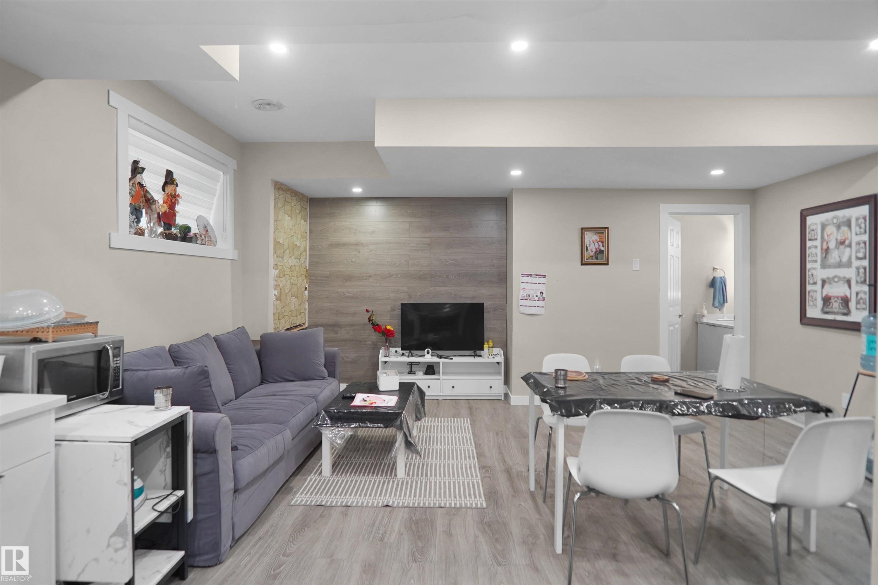 Open-concept living space featuring recessed lighting, light wood-finish flooring, and a window with white trim - 6108 173 Ave, Edmonton, AB - Indoor