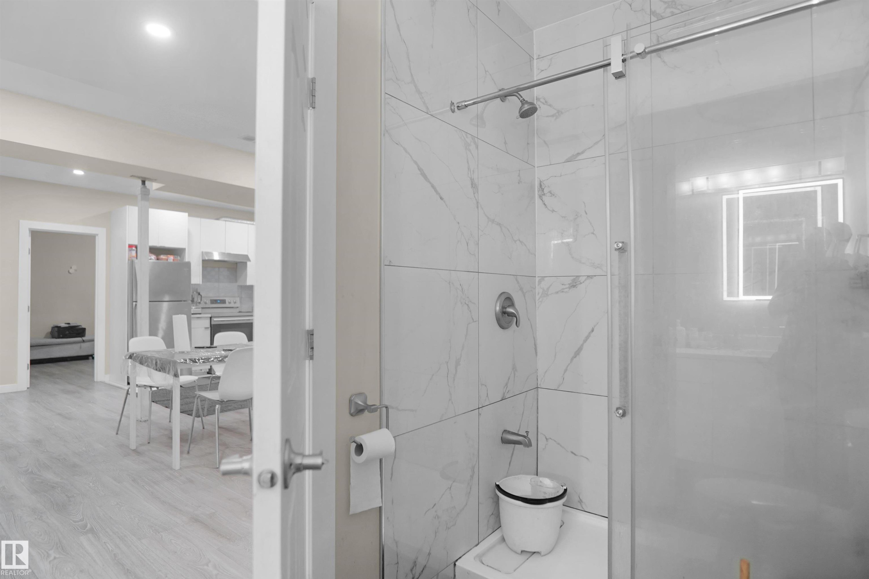 Modern bathroom featuring a tiled shower with a sliding glass door and contemporary fixtures - 6108 173 Ave, Edmonton, AB - Indoor Photo Showing Bathroom