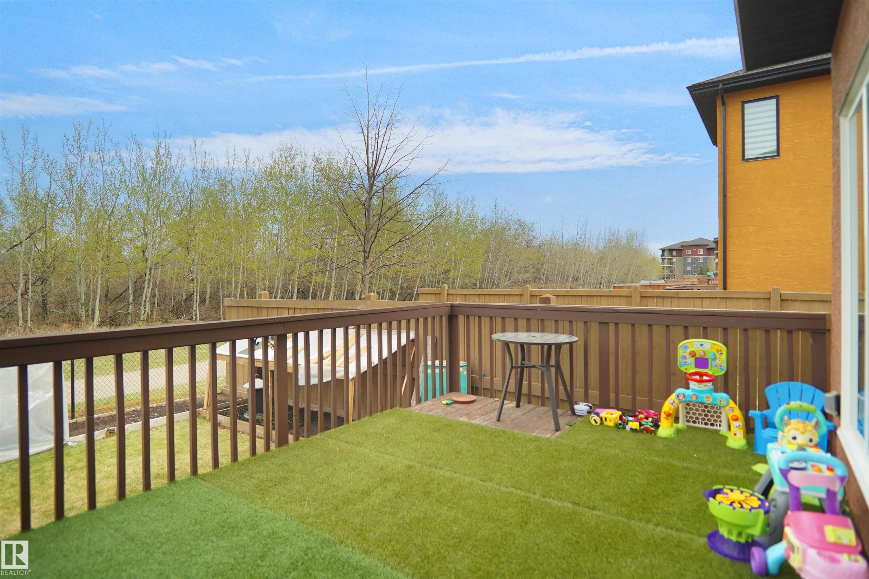 Rear deck featuring artificial turf and a wooden railing - 6108 173 Ave, Edmonton, AB - Outdoor With Deck Patio Veranda