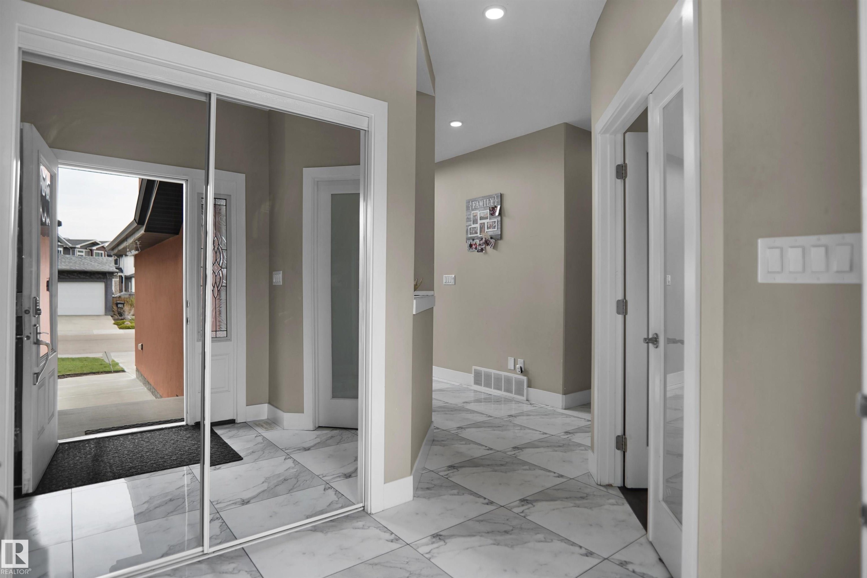 Entryway featuring large format marble-look tile flooring, a mirrored closet door, recessed lighting, and a glass-paneled interior door - 6108 173 Ave, Edmonton, AB - Indoor Photo Showing Other Room