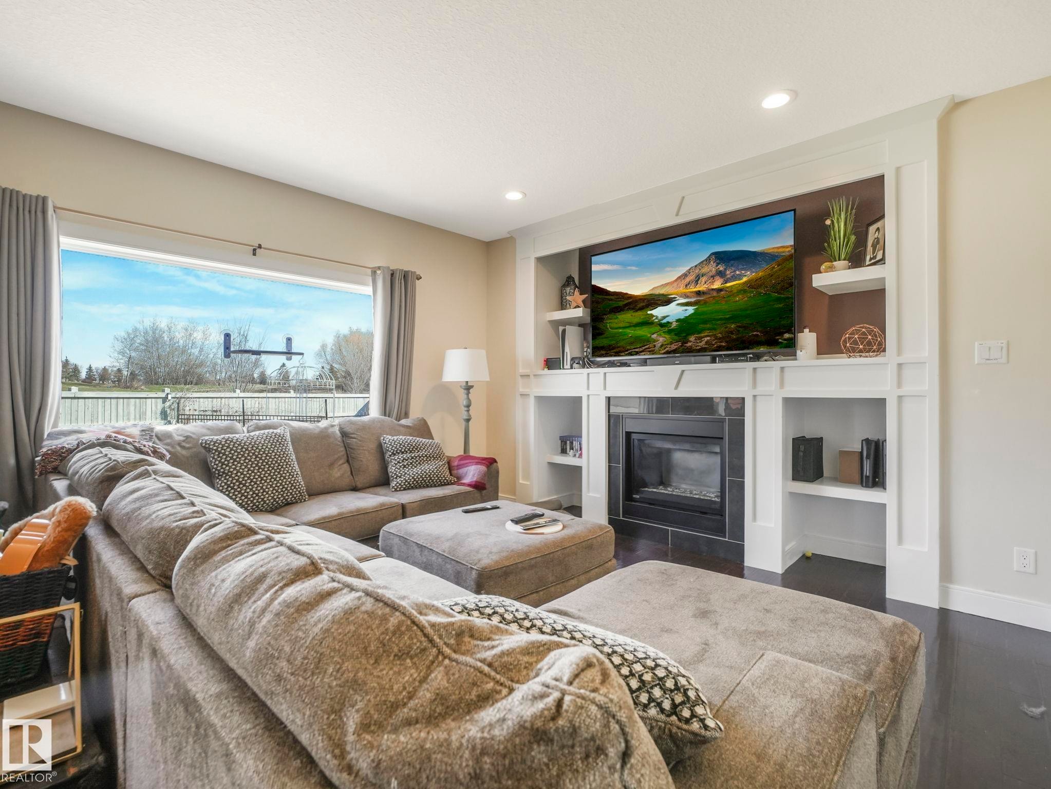 Expansive living area with large window framing the outdoor space - 3910 49 Avenue, Beaumont, AB - Indoor Photo Showing Living Room With Fireplace