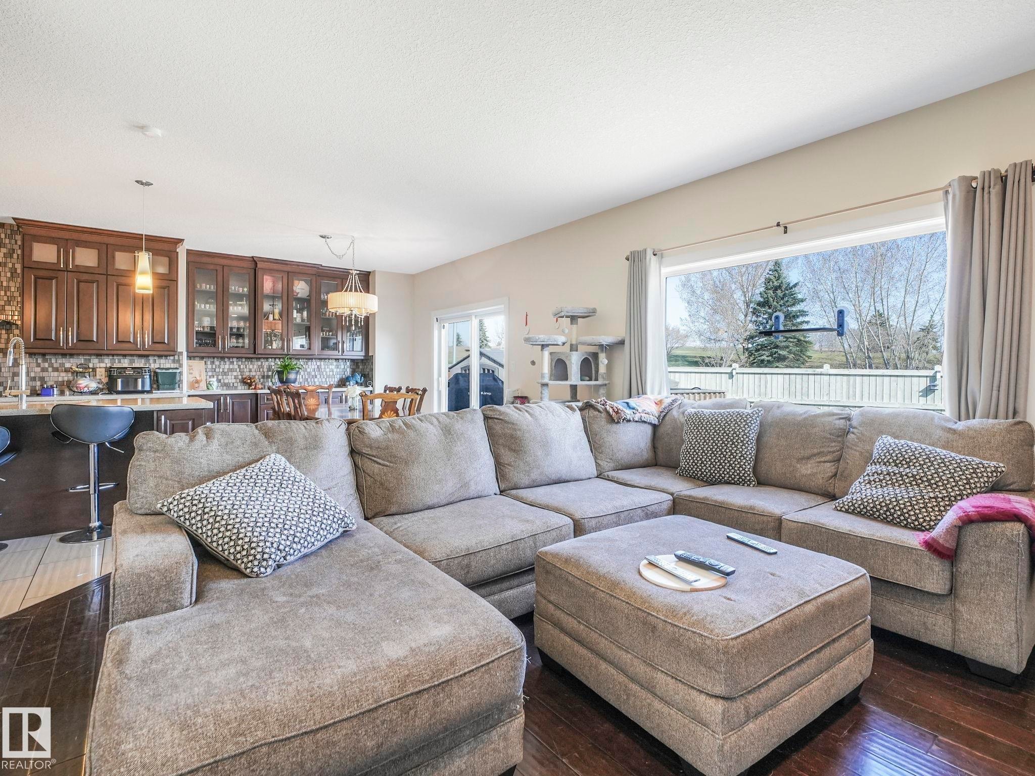Open-concept living area featuring rich wood-finish flooring - 3910 49 Avenue, Beaumont, AB - Indoor Photo Showing Living Room