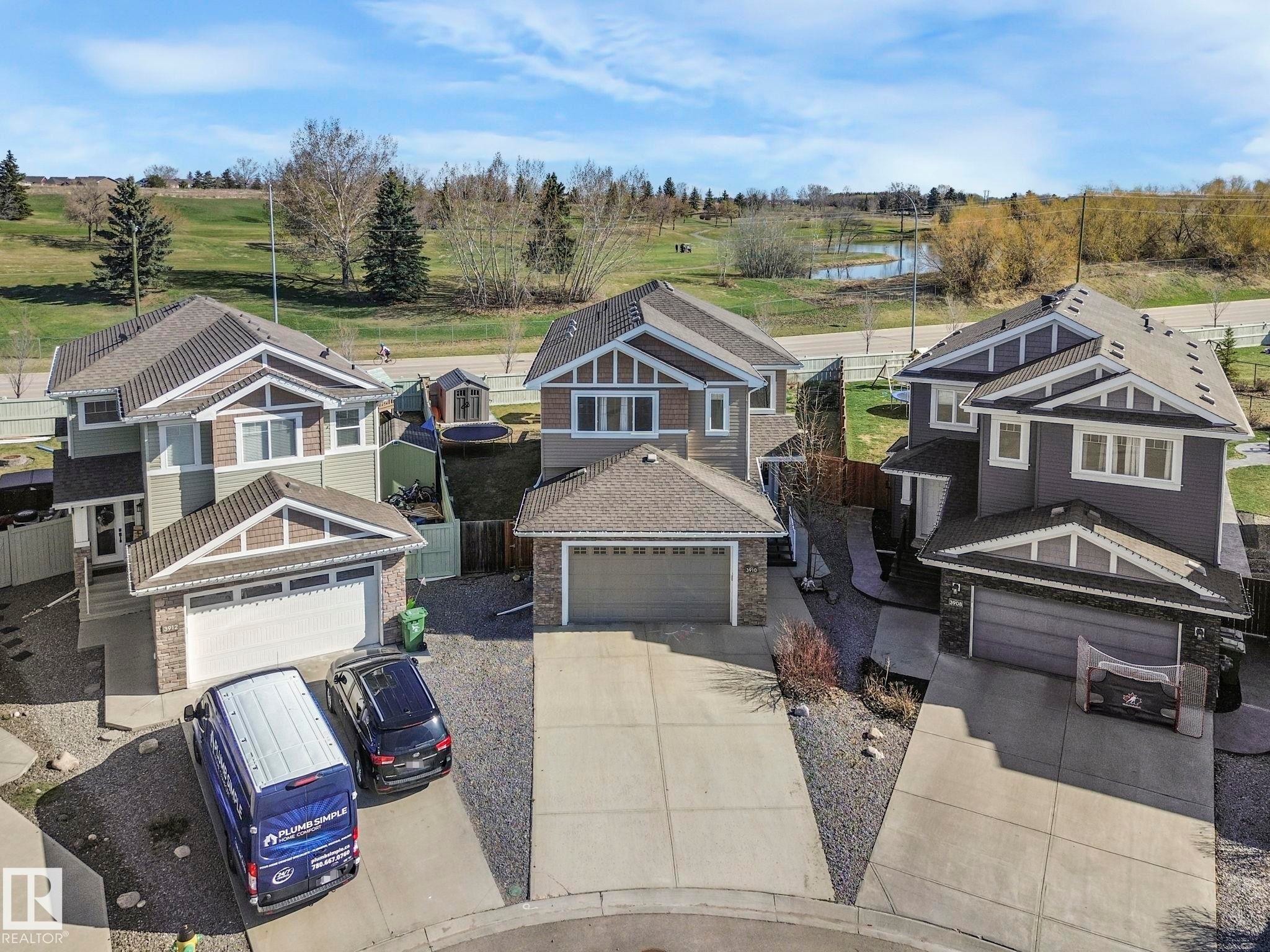 Three distinct residences featuring concrete driveways, attached garages, and pitched shingle roofs - 3910 49 Avenue, Beaumont, AB - Outdoor