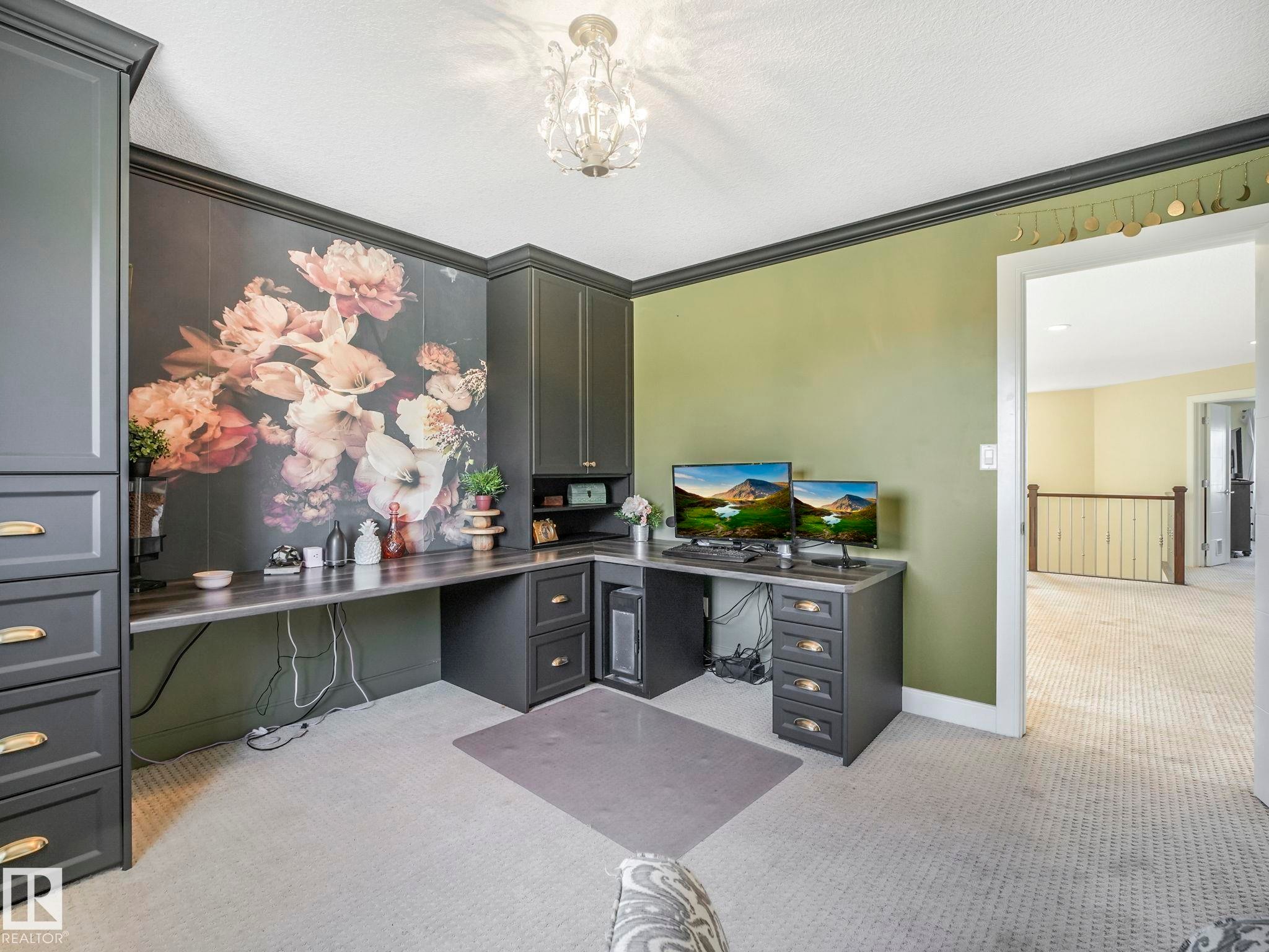 Dedicated workspace featuring built-in charcoal cabinetry, a wraparound desk surface, and a floral accent wall - 3910 49 Avenue, Beaumont, AB - Indoor Photo Showing Office