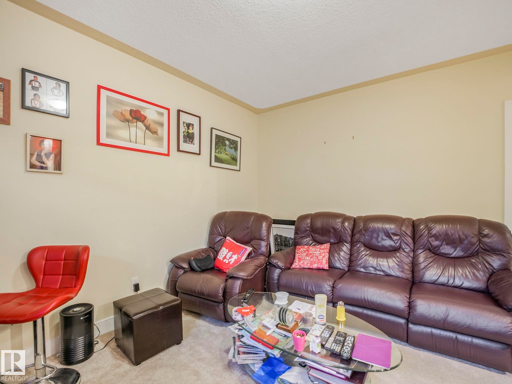 Light-colored walls with crown molding, carpeted flooring, and wall-mounted art - 3910 49 Avenue, Beaumont, AB - Indoor Photo Showing Living Room