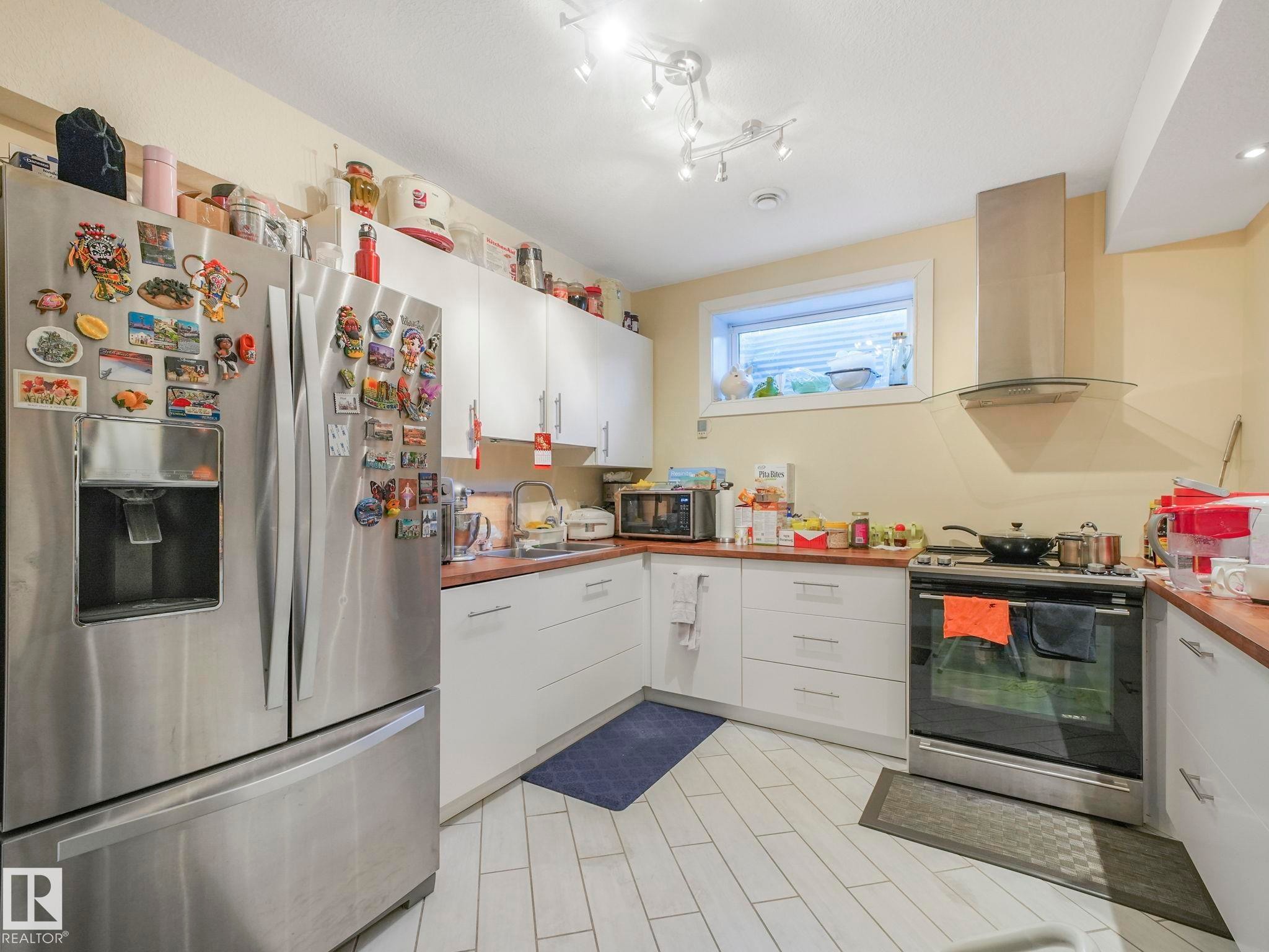 Kitchen featuring white cabinetry, light countertops, and light-toned tile flooring - 3910 49 Avenue, Beaumont, AB - Indoor Photo Showing Kitchen