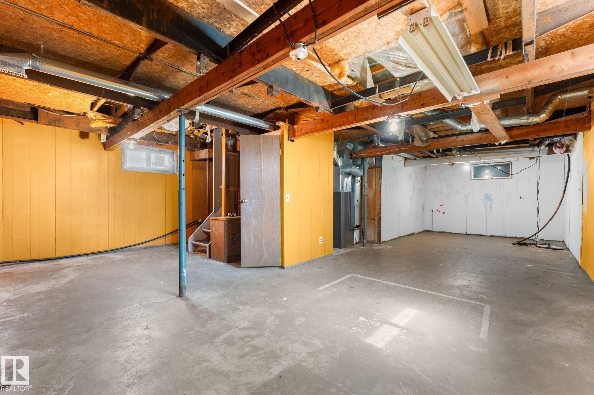 Unfinished basement space featuring exposed wood joists, concrete flooring, and a utility window - 4508 50A Avenue, Barrhead, AB - Indoor Photo Showing Basement