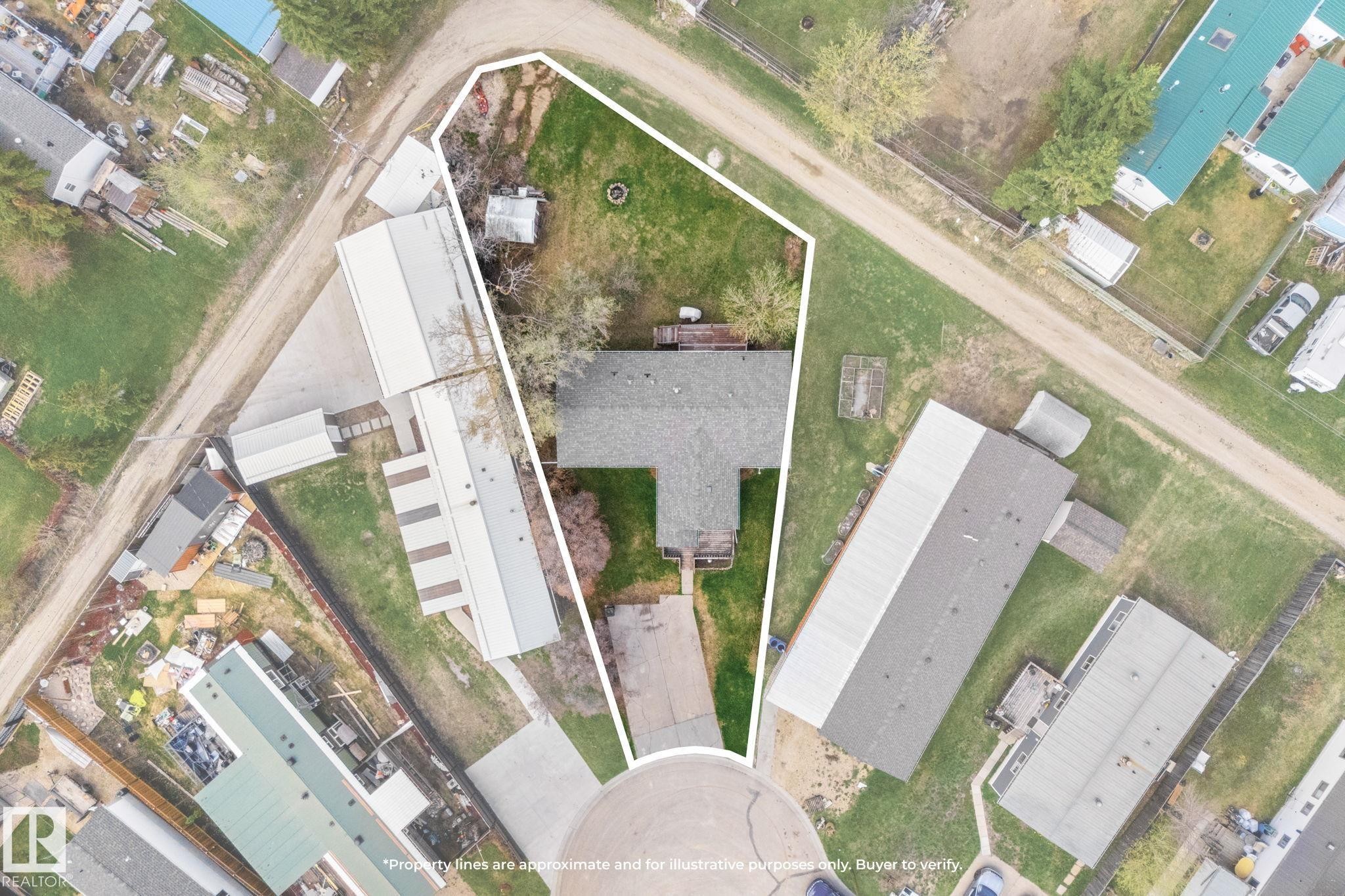 Aerial view highlighting the property's irregular lot shape, featuring a central residence with a gray shingle roof - 4508 50A Avenue, Barrhead, AB -
