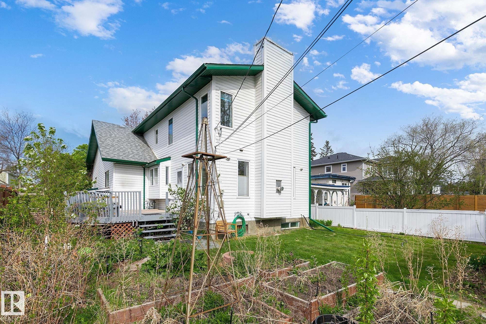 Rear exterior featuring white siding with green trim - 10823 130 Street, Edmonton, AB - Outdoor With Deck Patio Veranda