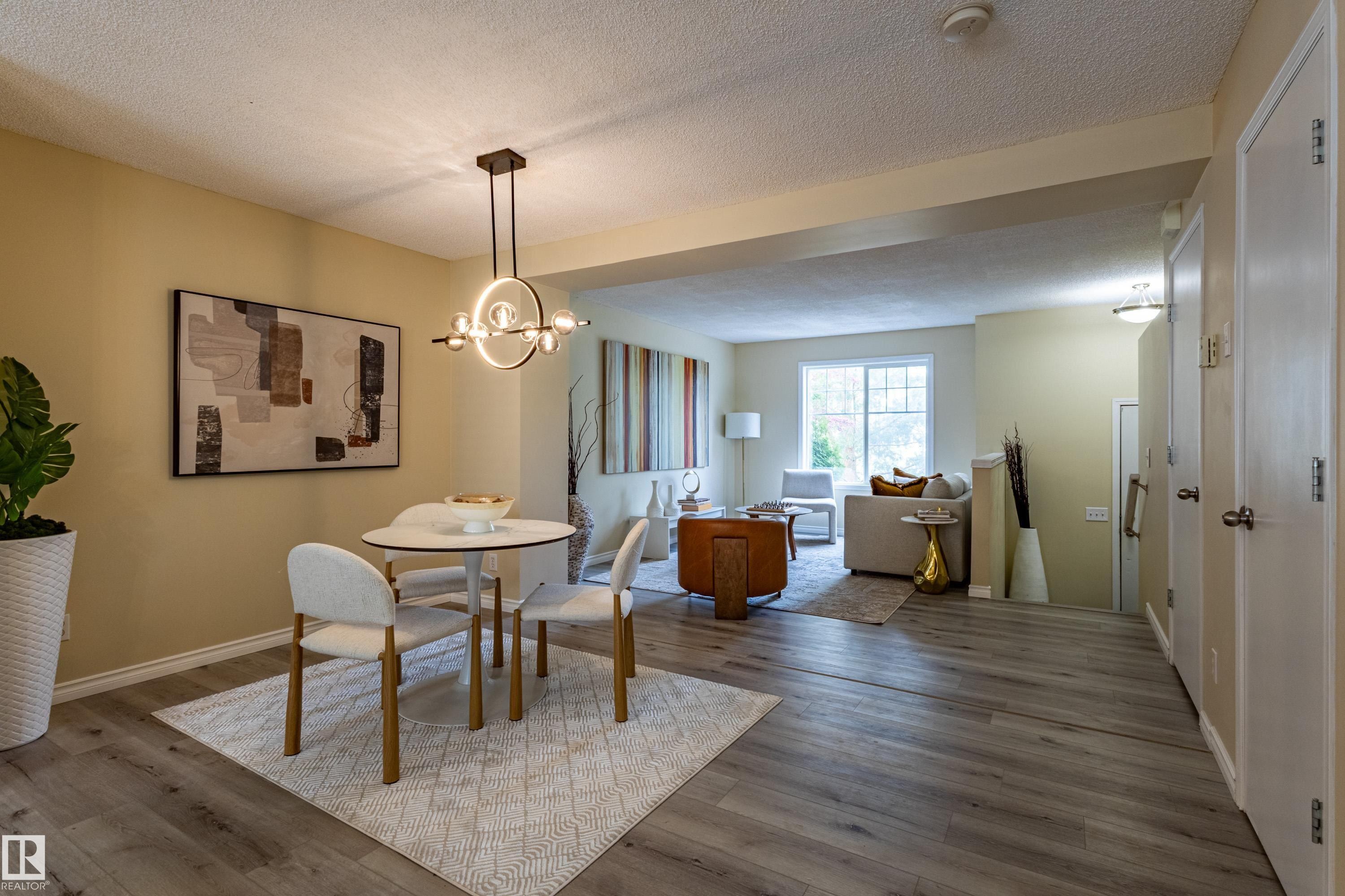 Open-concept living area featuring wood-finish flooring, a contemporary chandelier, recessed lighting, and a sliding glass door - 41 8304 11 Avenue, Edmonton, AB - Indoor Photo Showing Dining Room