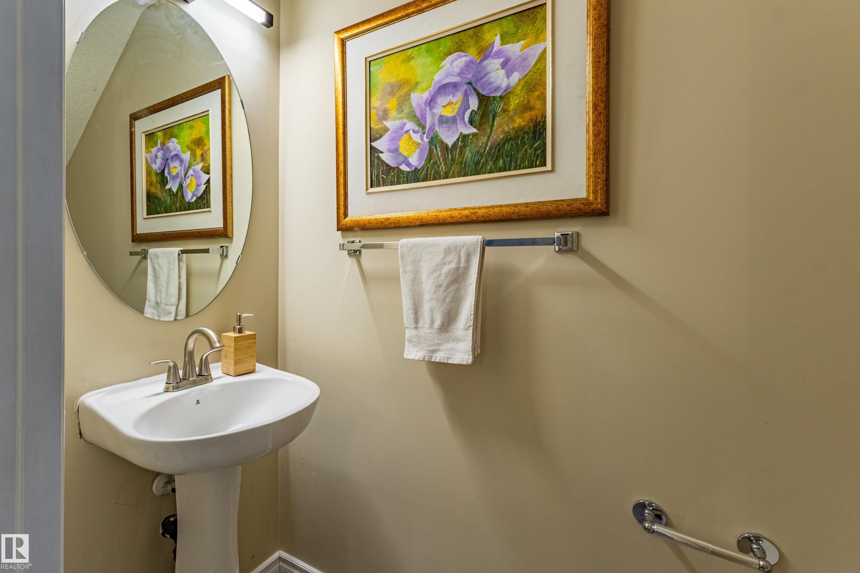 Pedestal sink with chrome faucet, illuminated by an overhead bar light - 41 8304 11 Avenue, Edmonton, AB - Indoor Photo Showing Bathroom