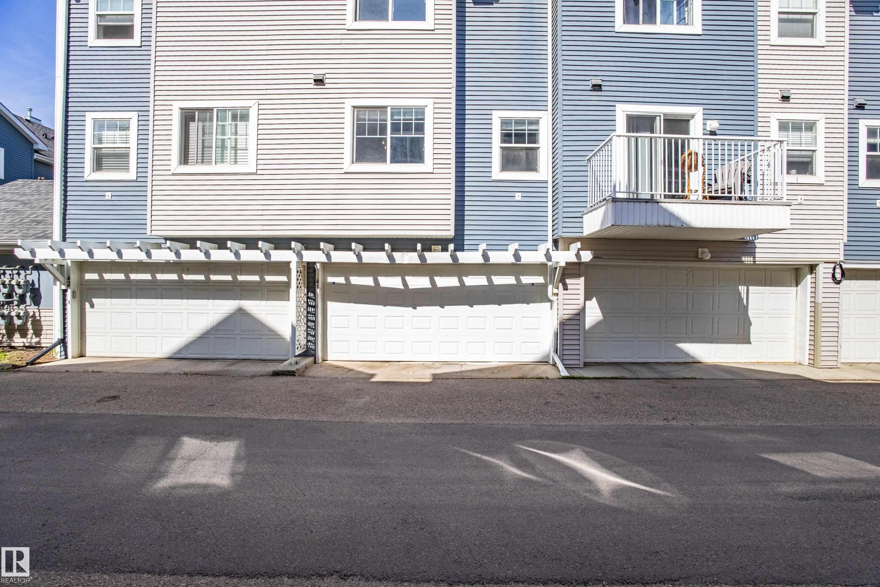 Multi-level building with horizontal siding in varying blue and grey tones - 41 8304 11 Avenue, Edmonton, AB - Outdoor