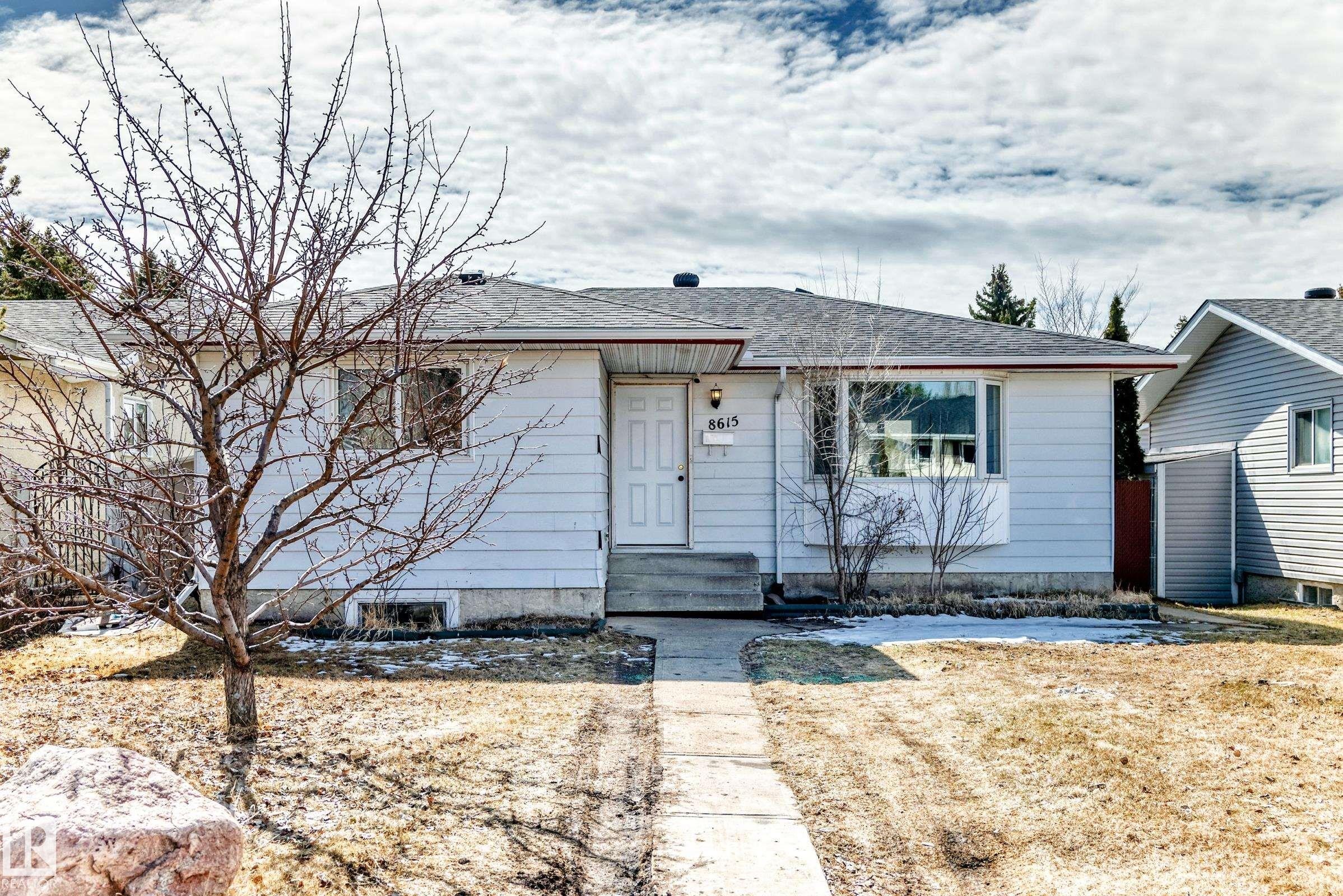 Single-story residence featuring light-colored siding, a prominent front door with house numbers, and a large bay window - 8615 42A Avenue, Edmonton, AB - Outdoor