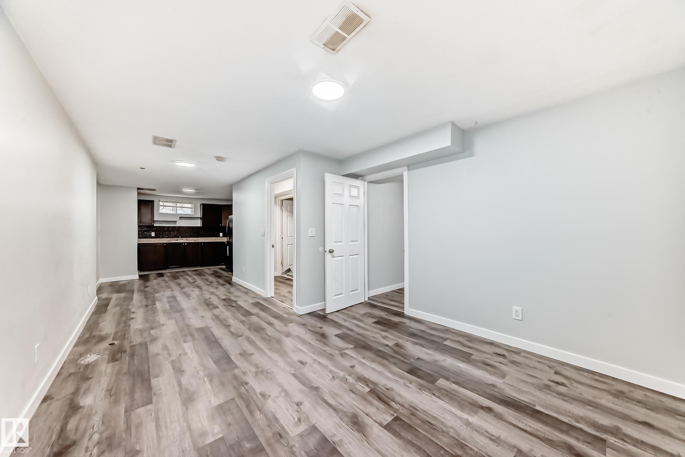 Open-concept living space featuring wood-finish flooring, recessed lighting, and a neutral color palette - 8615 42A Avenue, Edmonton, AB - Indoor Photo Showing Other Room
