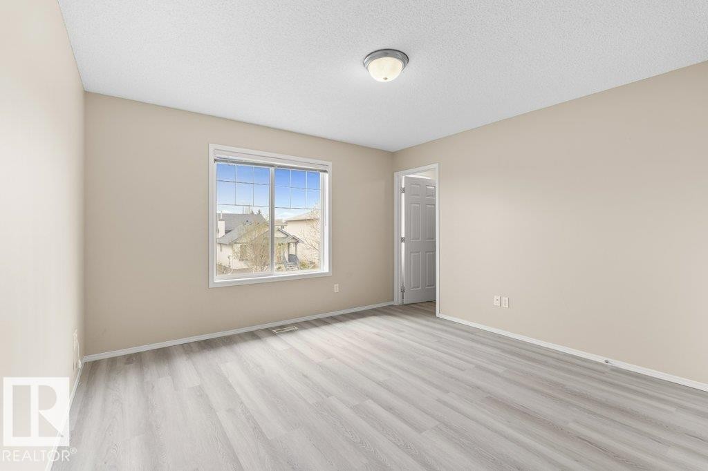 Neutral-toned walls complement light wood-finish flooring - 21344 88 Avenue, Edmonton, AB - Indoor Photo Showing Other Room