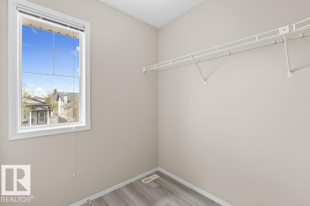 Bright room featuring a large window, neutral wall paint, and wood-finish flooring - 21344 88 Avenue, Edmonton, AB - Indoor With Storage