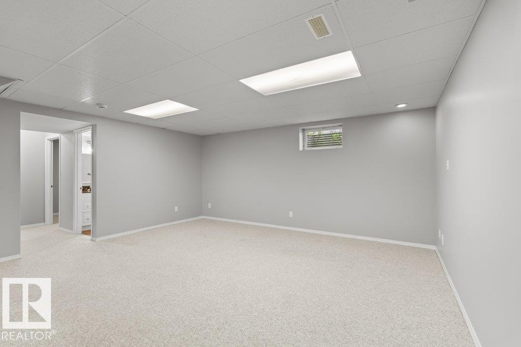 Spacious room featuring light-colored carpeting, neutral painted walls, and a drop ceiling with recessed lighting - 21344 88 Avenue, Edmonton, AB - Indoor Photo Showing Basement
