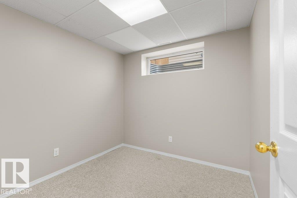 Neutral-toned wall space with light-colored carpeting, a drop ceiling, and a high horizontal window - 21344 88 Avenue, Edmonton, AB - Indoor Photo Showing Other Room