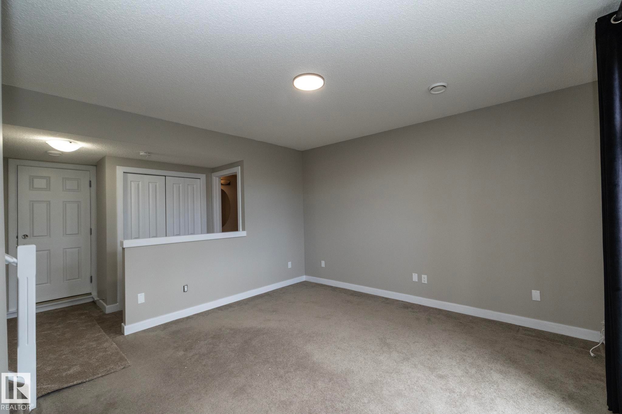 Neutral tone wall paint with white trim, recessed lighting, and carpeted flooring - 117 Callaghan Drive Sw, Edmonton, AB - Indoor Photo Showing Other Room