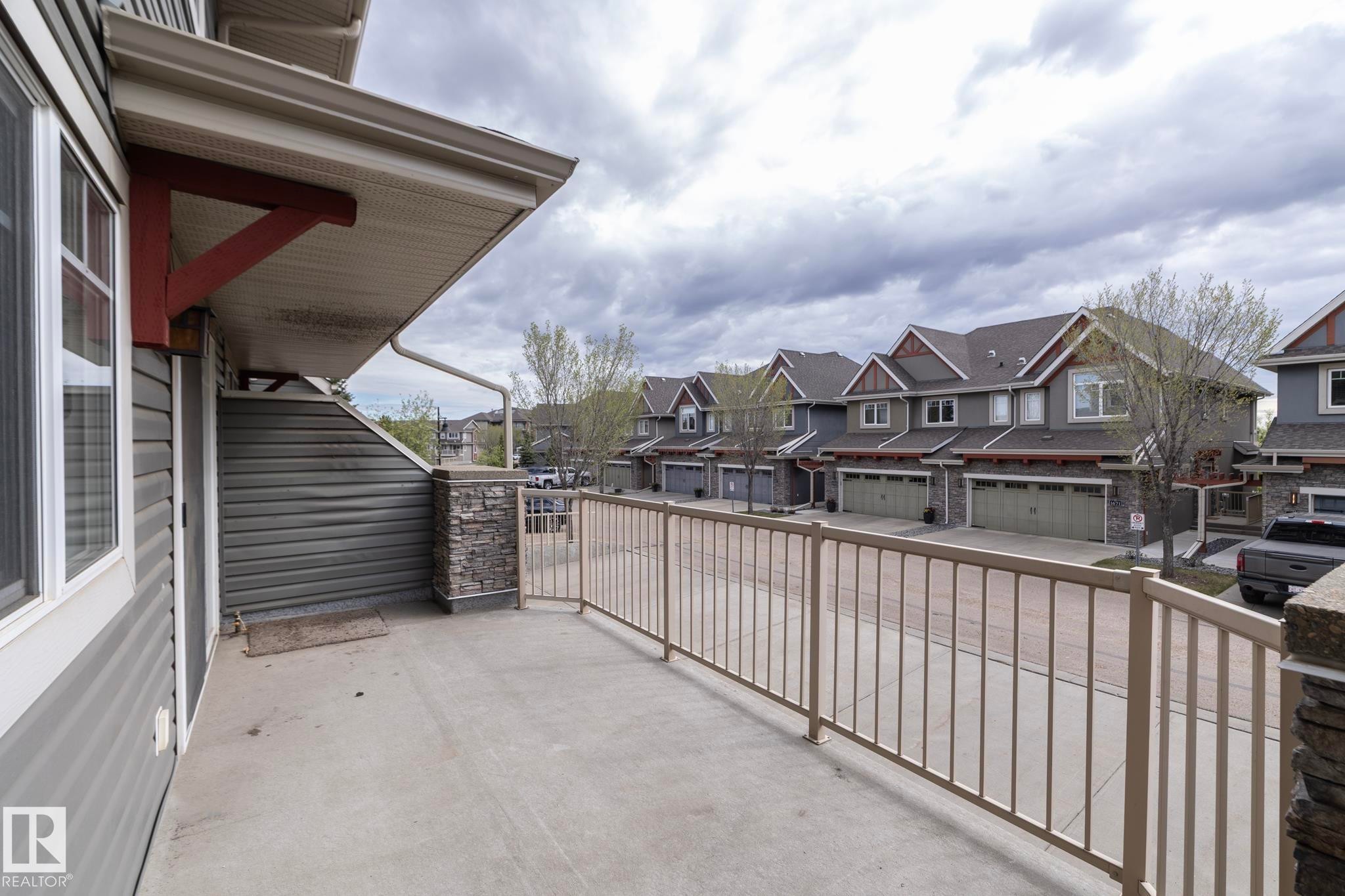 Concrete balcony with a light-toned metal railing - 117 Callaghan Drive Sw, Edmonton, AB - Outdoor With Exterior