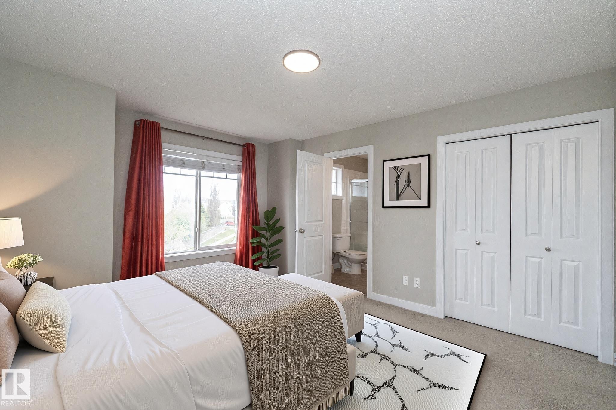 Carpeted room featuring a double window, two white bi-fold closet doors, and light gray painted walls - 117 Callaghan Drive Sw, Edmonton, AB - Indoor Photo Showing Bedroom