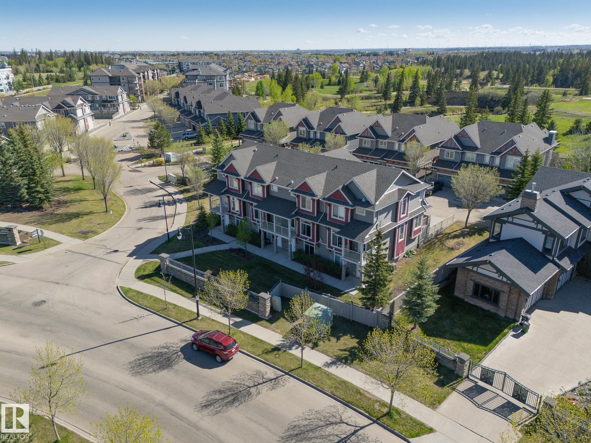 Townhome-style residences with contrasting siding colors and gabled roofs - 117 Callaghan Drive Sw, Edmonton, AB - Outdoor With View