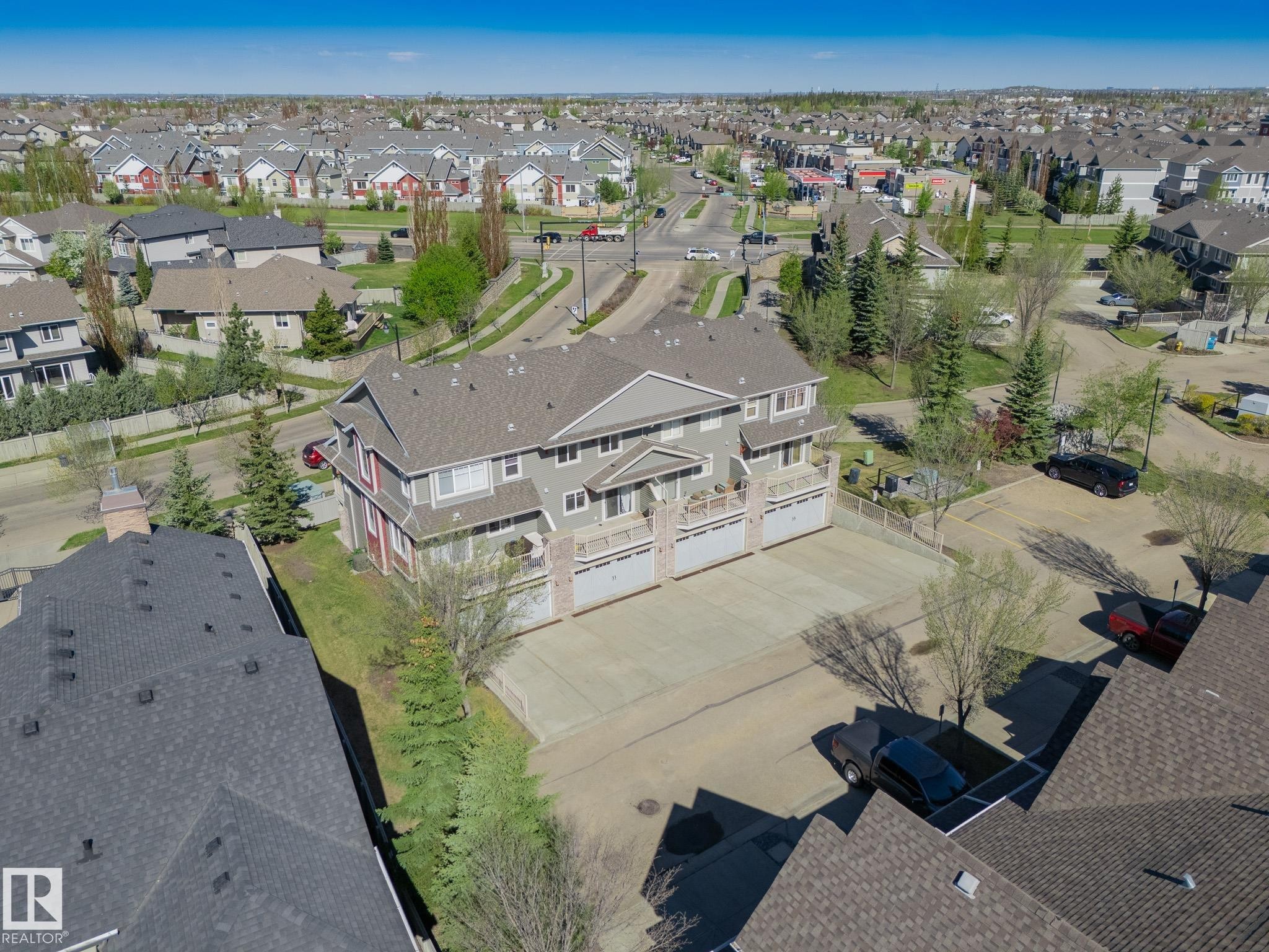 Multi-unit residential structure featuring a gray exterior siding, individual garage doors, and private balconies - 117 Callaghan Drive Sw, Edmonton, AB - Outdoor With View
