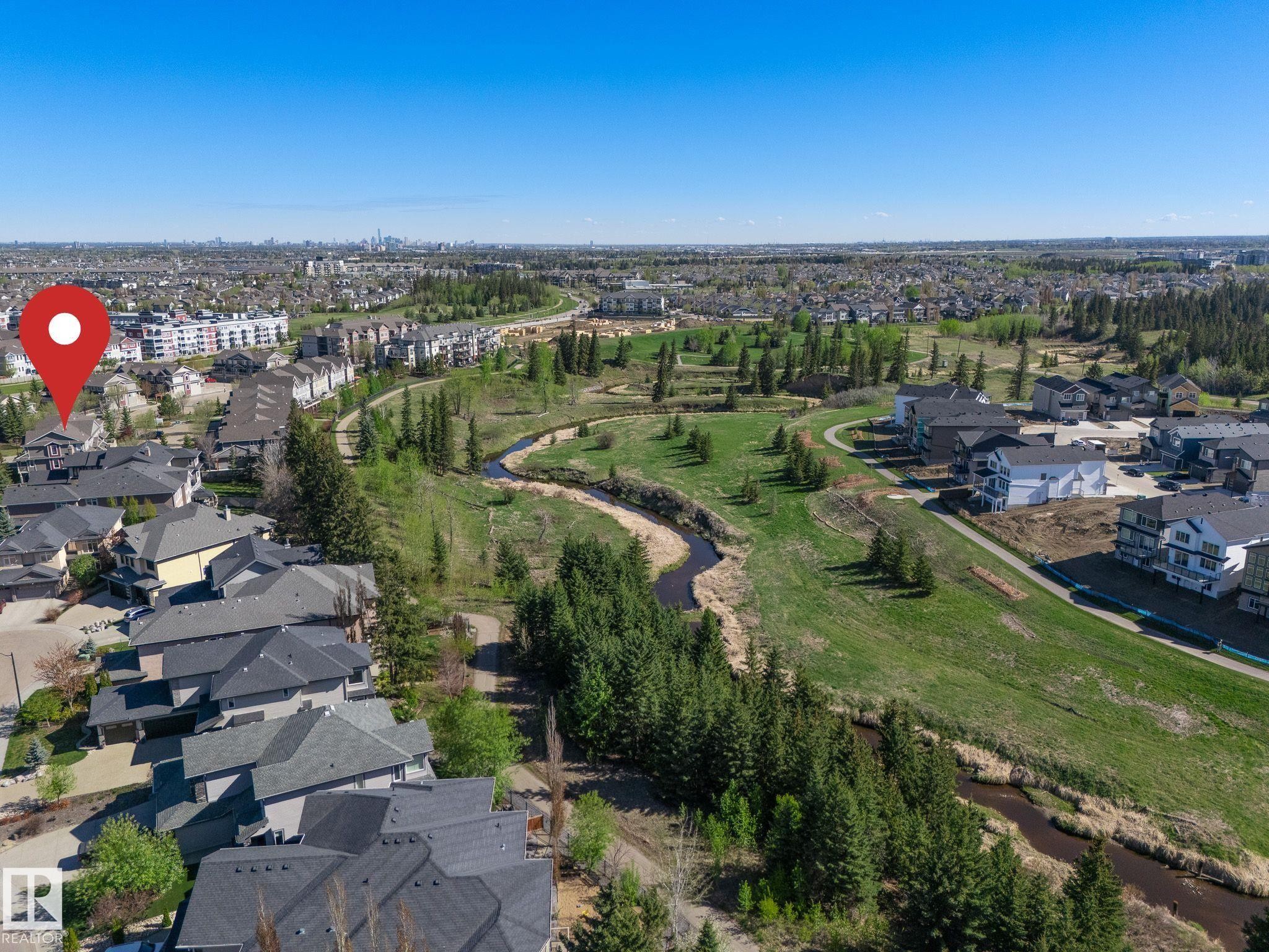 Suburban landscape featuring a meandering creek, extensive green spaces, and mature evergreen trees - 117 Callaghan Drive Sw, Edmonton, AB - Outdoor With View