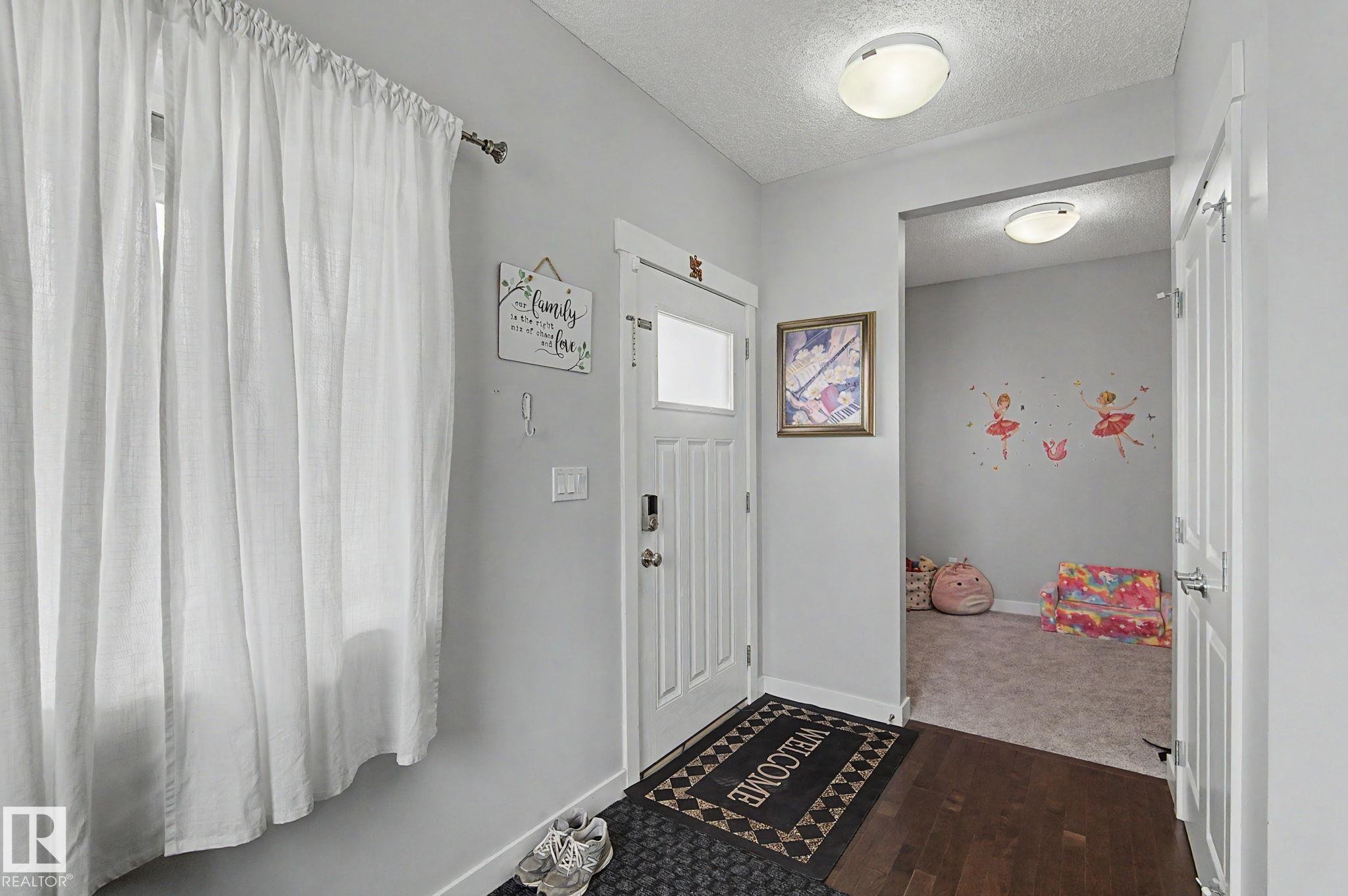 Entryway featuring dark wood-finish flooring and a white paneled door with an integrated window - 18144 76 Street Nw, Edmonton, AB - Indoor Photo Showing Other Room