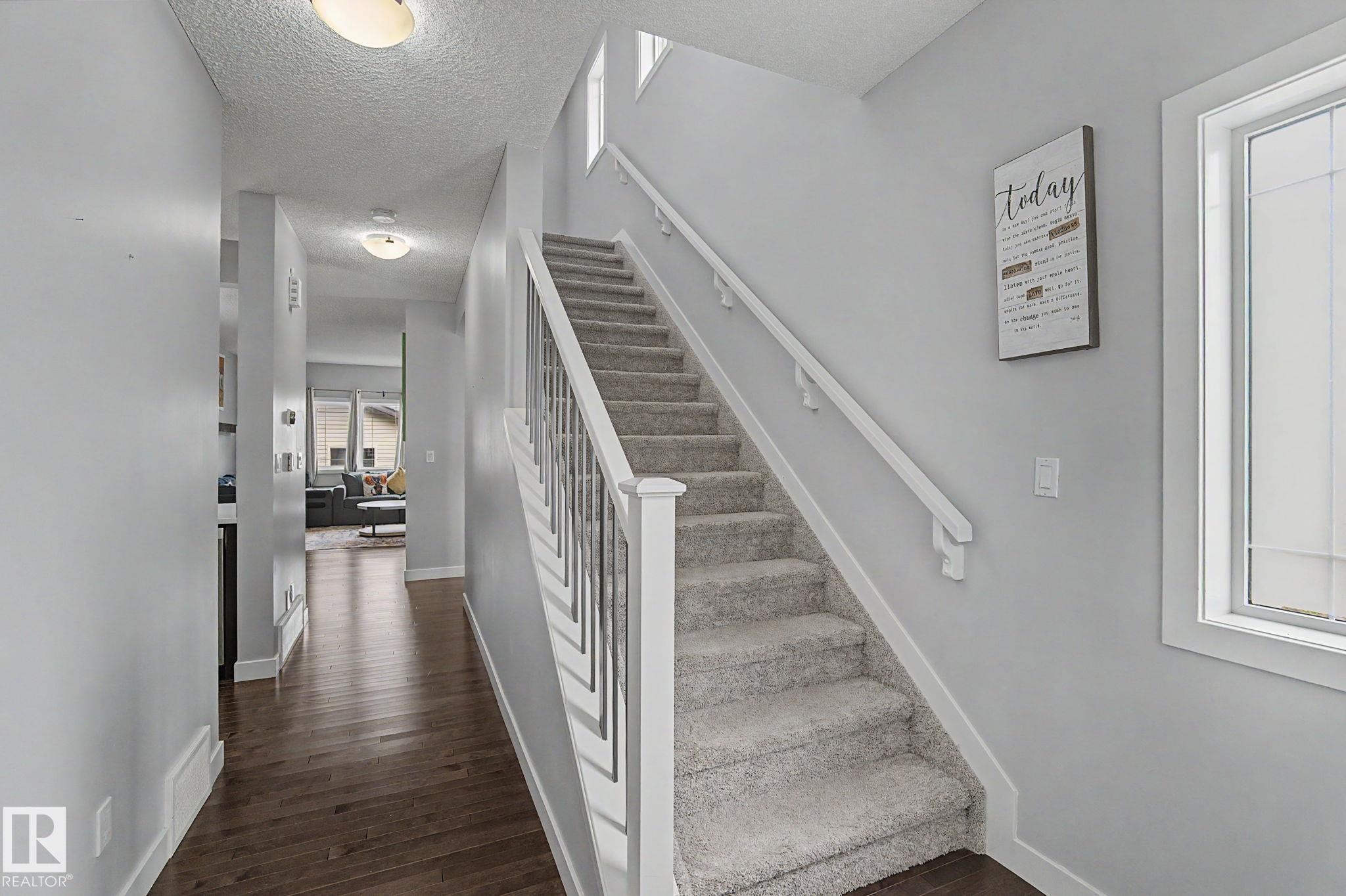 Carpeted staircase with white balusters and handrails - 18144 76 Street Nw, Edmonton, AB - Indoor Photo Showing Other Room
